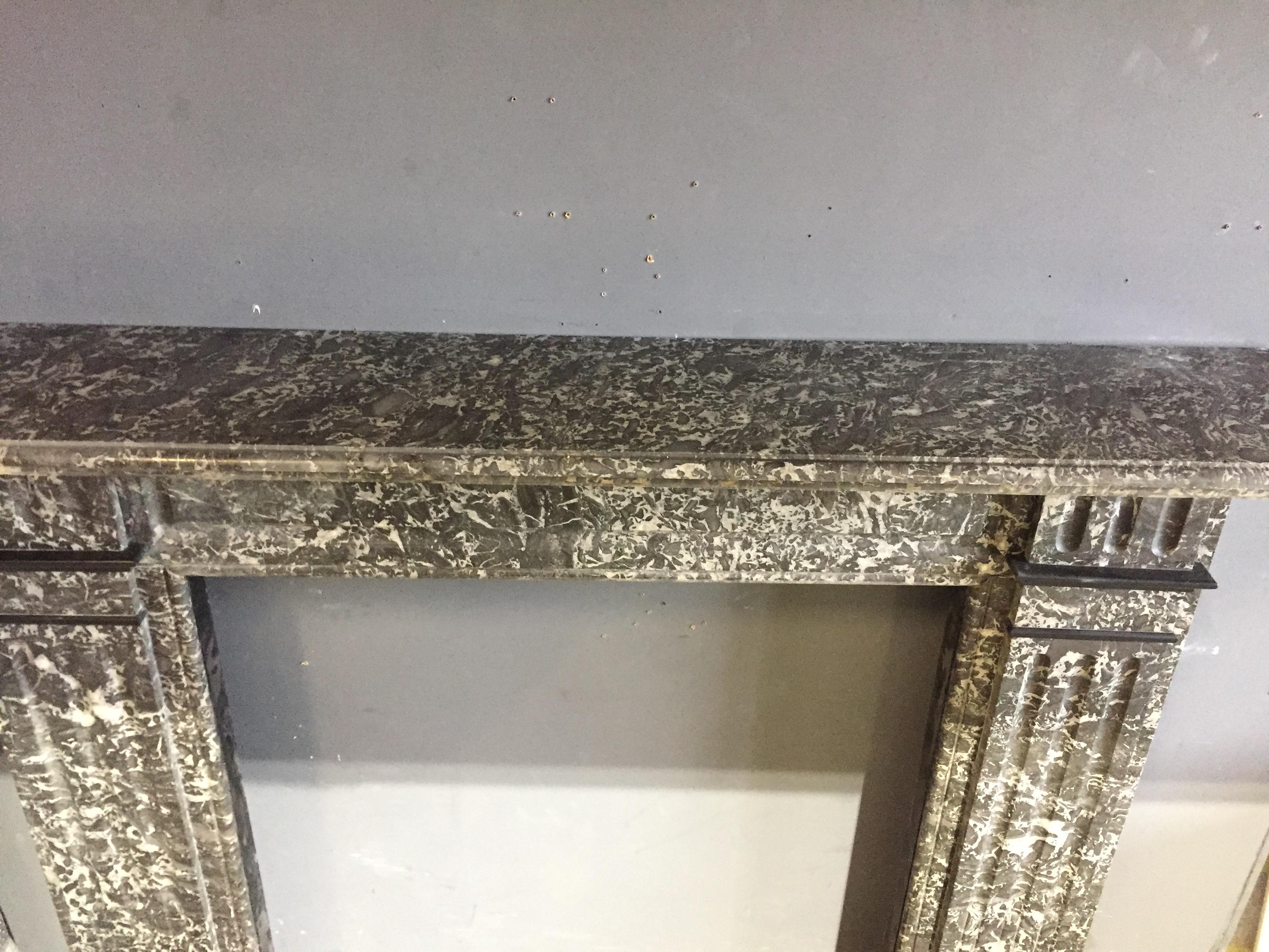 Edwardian mantel made in St. Anne's Noire marble with welsh slate fillets including its original curb fender. Opening dimensions: 36.5