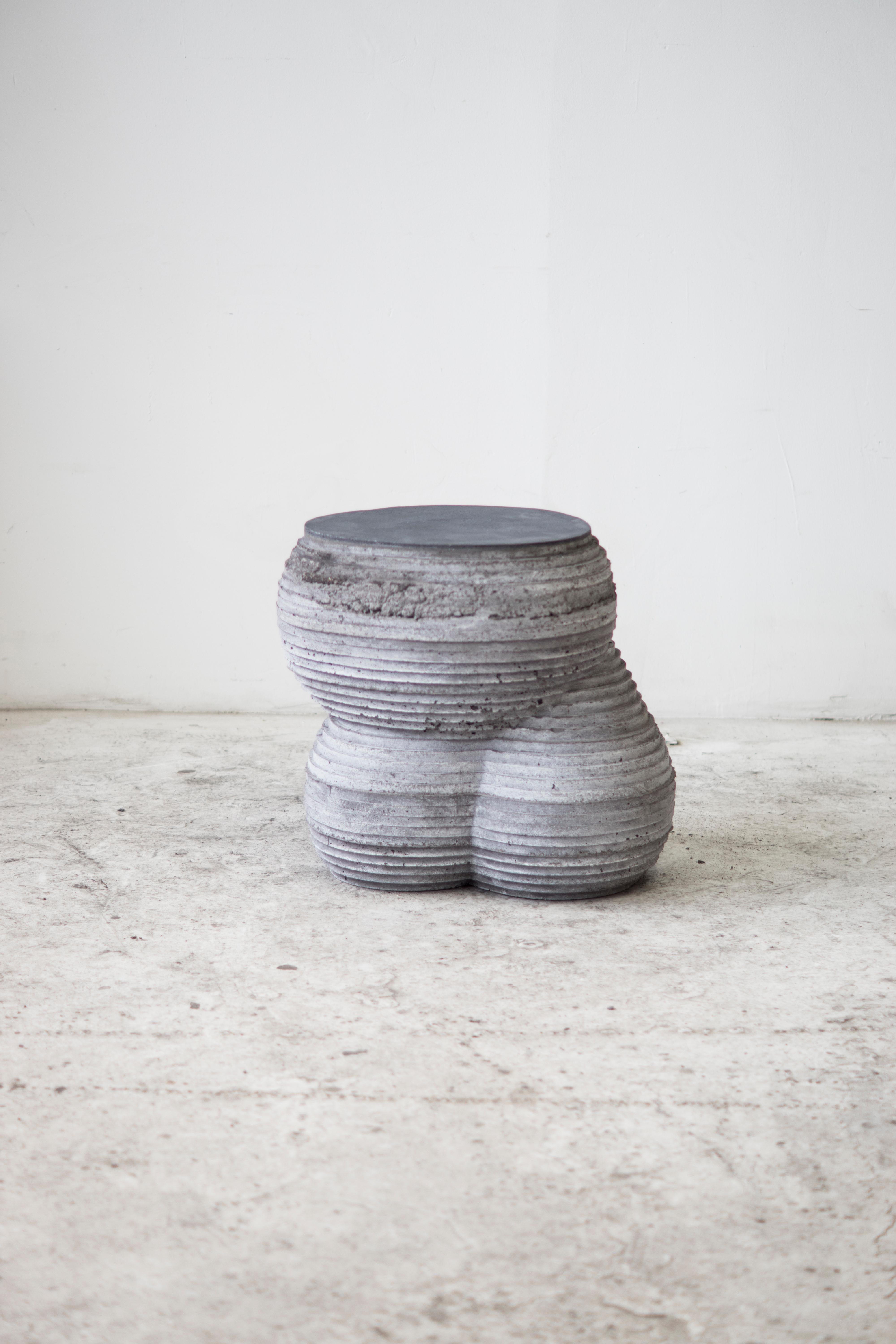 SIDE TABLE / STOOL. 

At the intersection of art, craft, and design, Concrete Poetics' debut collection of hand-cast cement sculptural furniture and accessories streamlines visually intriguing and dynamic forms juxtaposing the density of the