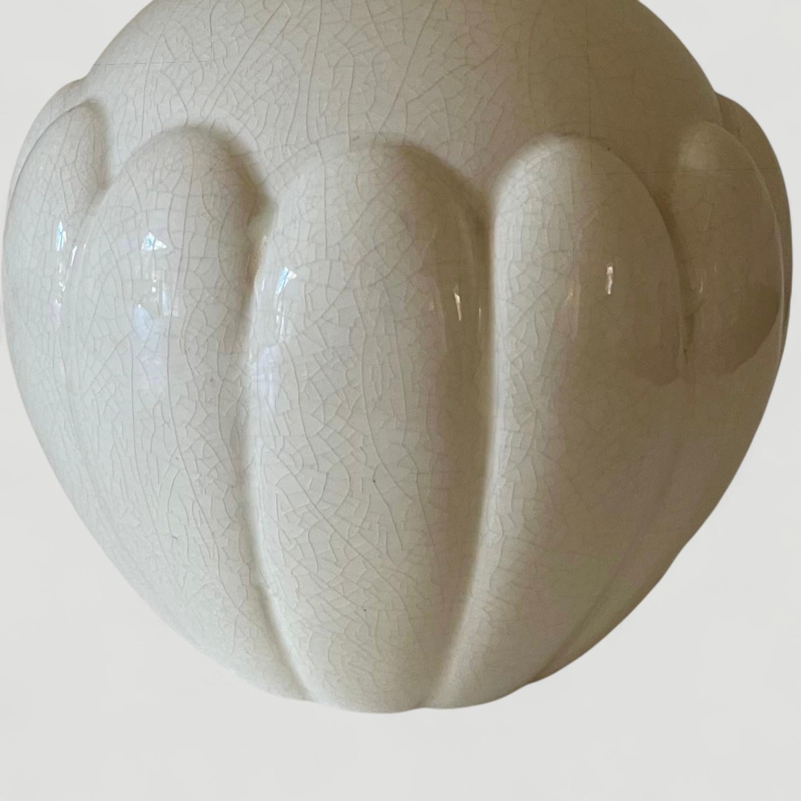 Keramikvase Saint Clement, Frankreich, mit weißer Craquelé-Glasur. Eine atemberaubende  runde Vase mit  mit kleiner Kragenöffnung und detaillierter stilisierter  Form um den Sockel herum, um 1930

Höhe 7,5 Zoll
Tiefe 7,5 Zoll
