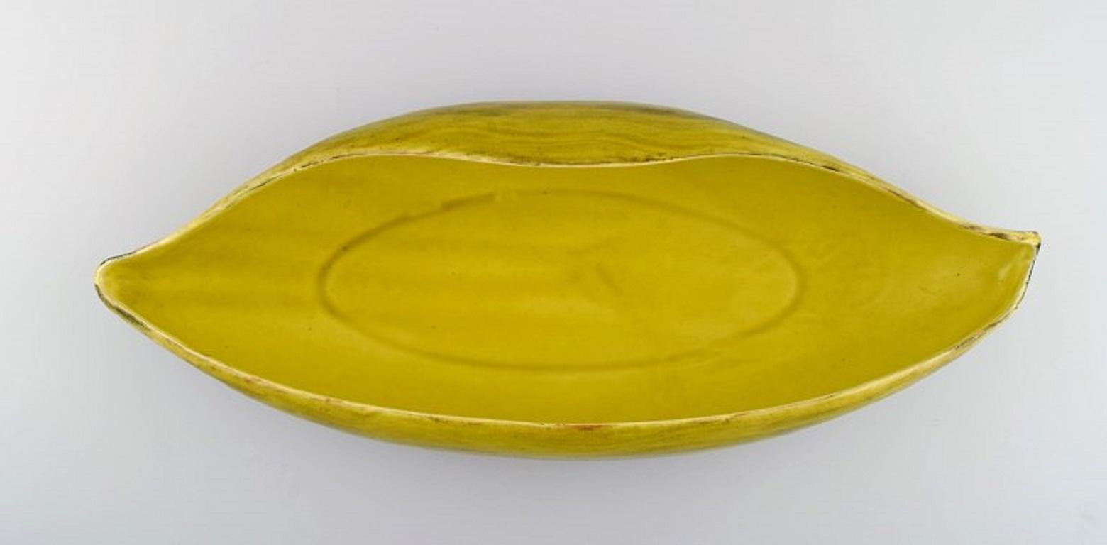 St. Clement, France. Colossal organically shaped bowl in hand-painted glazed stoneware. 
Beautiful glaze in yellow shades. Mid-20th century.
Measures: 51 x 19 cm.
Height: 9.5 cm.
In excellent condition.
Stamped.