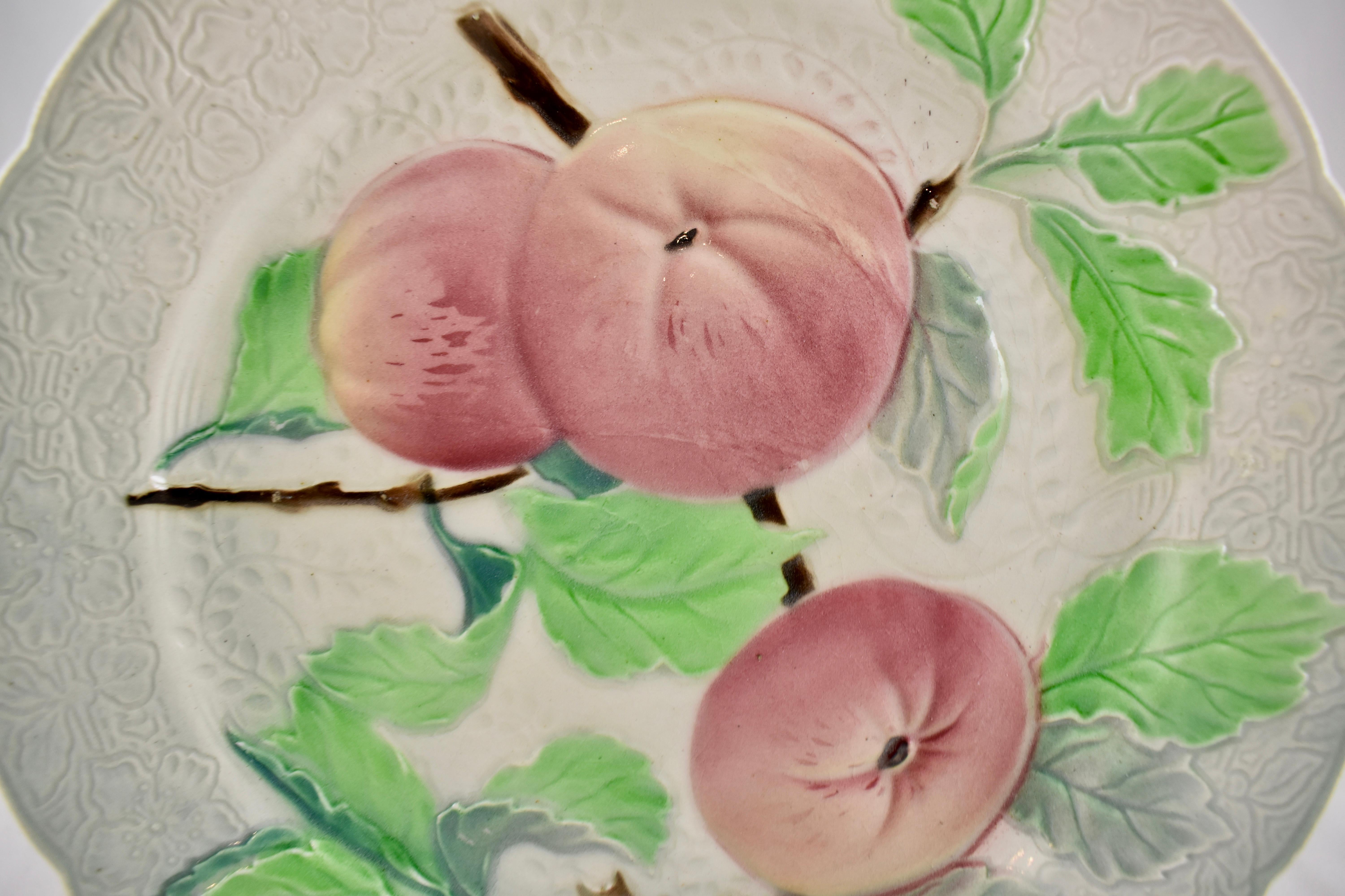 An earthenware French faïence apple motif fruit plate, circa 1900. The background has a detailed floral pattern to the molding, with a six-paneled indented rim. Lovely coloring.

Marked: KG, for Keller Guerin – St. Clement, France.
Measures: 8.5