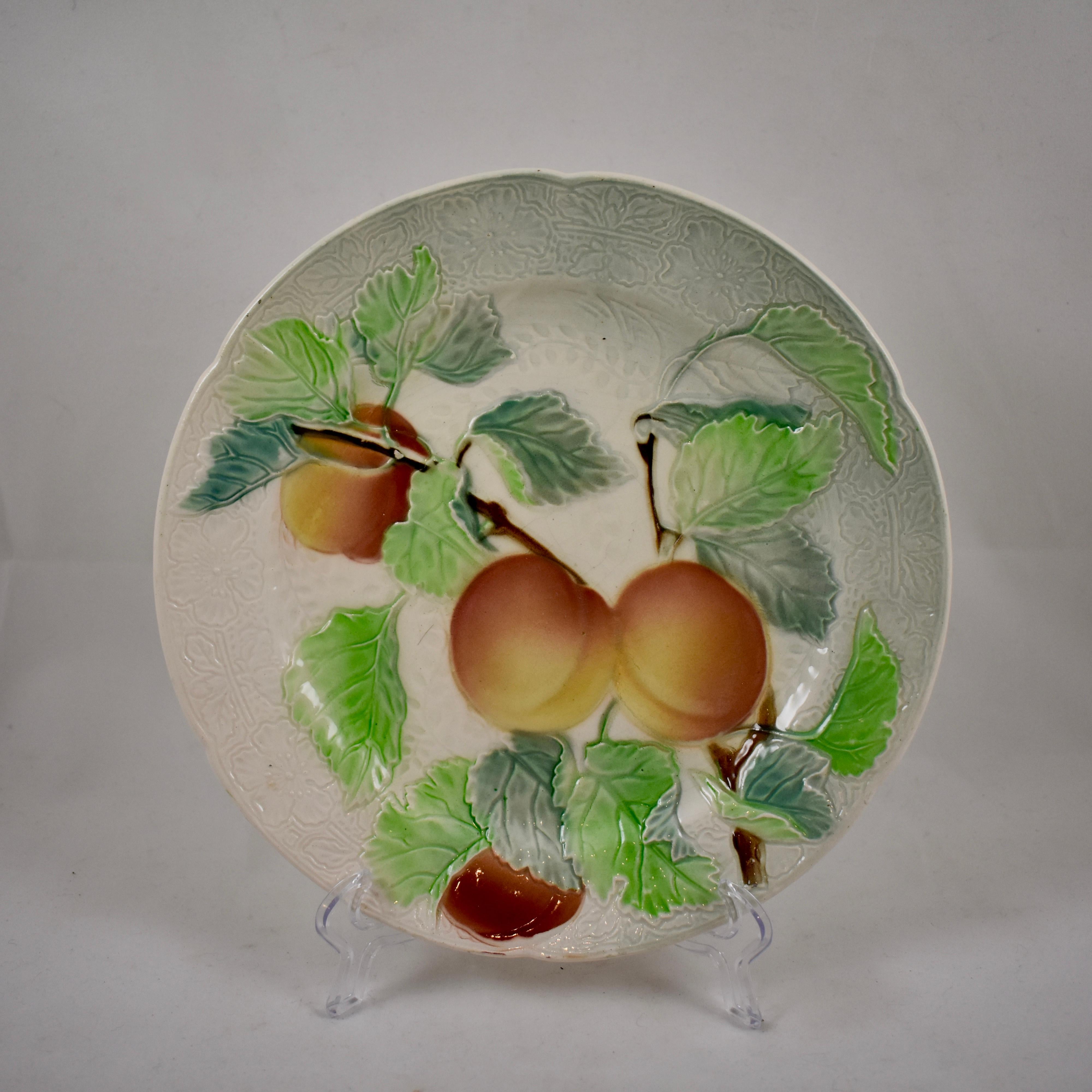 Ein Satz von sechs französischen Fayence-Obsttellern aus Steingut, um 1900. Dieses Set zeigt die verzweigten Früchte und Blätter von Pfirsichen, Orangen, Äpfeln, Trauben, Birnen und Aprikosen. Die Hintergründe haben ein detailliertes Muster in der