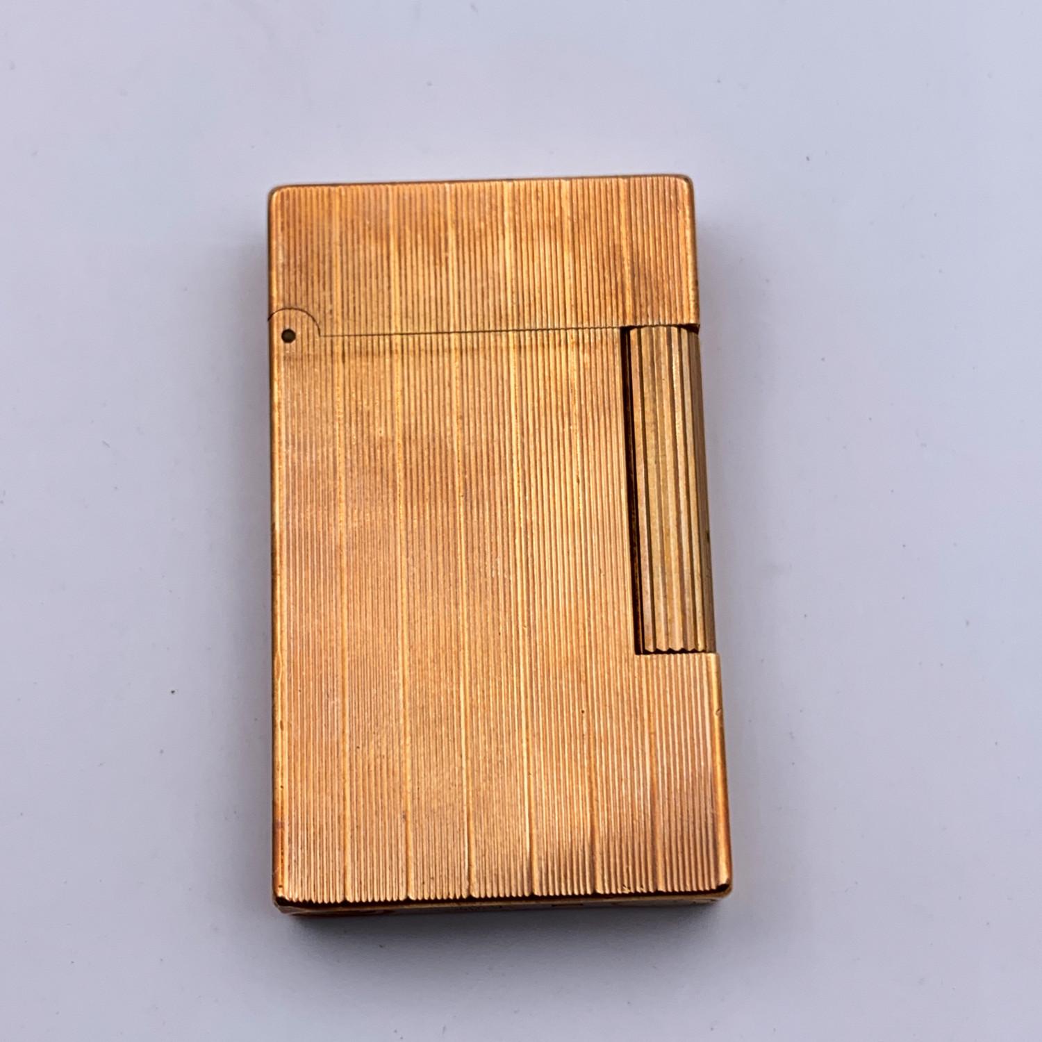 Vintage S.T. Dupont textured gold plated classic lighter. Long-roller lighter mechanism. 'ST DUPONT Paris - made in France' engraved on the base of the lighter. Total length: 2.5 inches - 6.3 cm. Original box and booklets