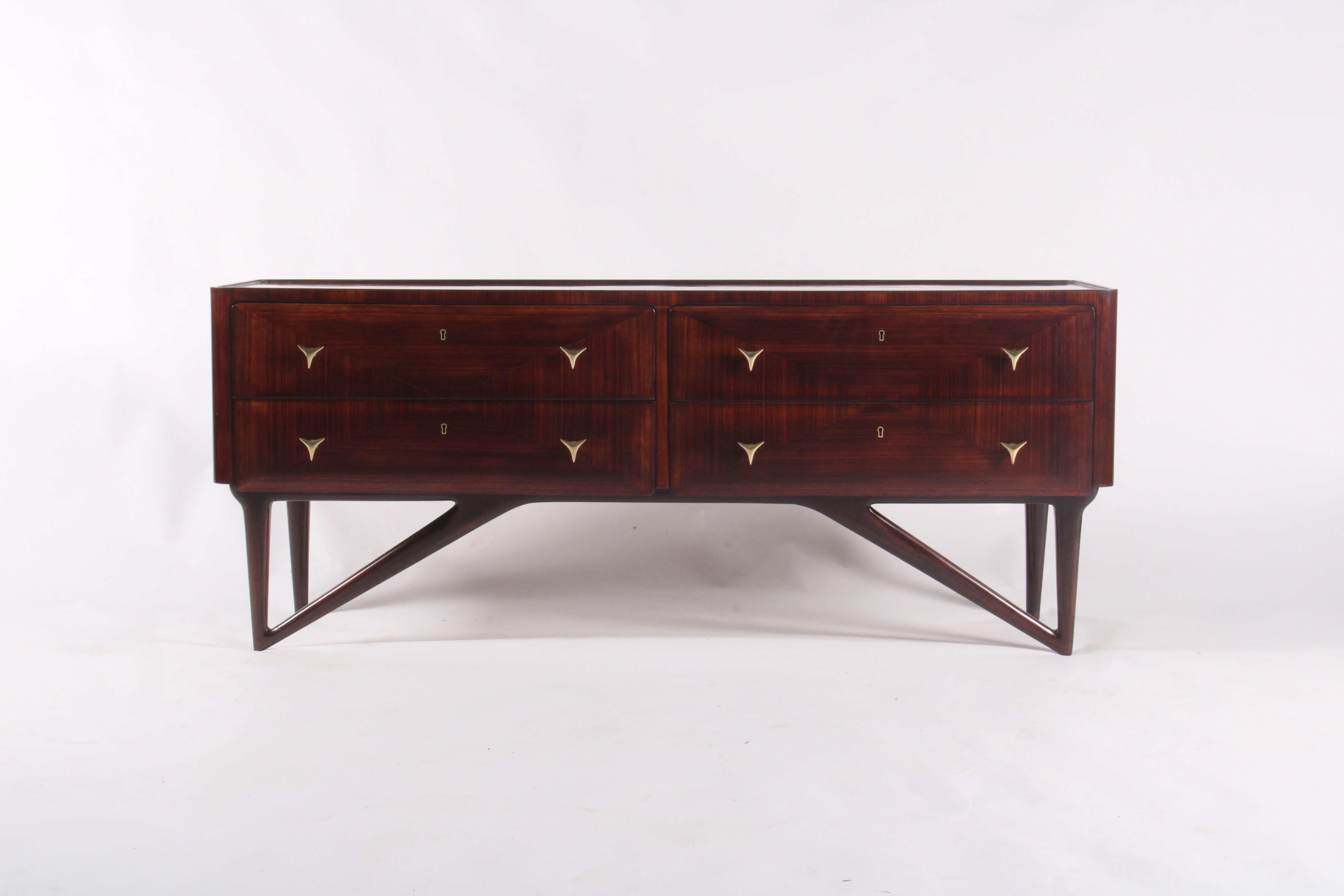 Questa eccezionale credenza italiana di metà secolo, realizzata intorno al 1950, è un raro e raffinato esempio di design modernista. Realizzato in legno di palissandro riccamente venato con dettagli di impiallacciatura in tinta con il libro, il