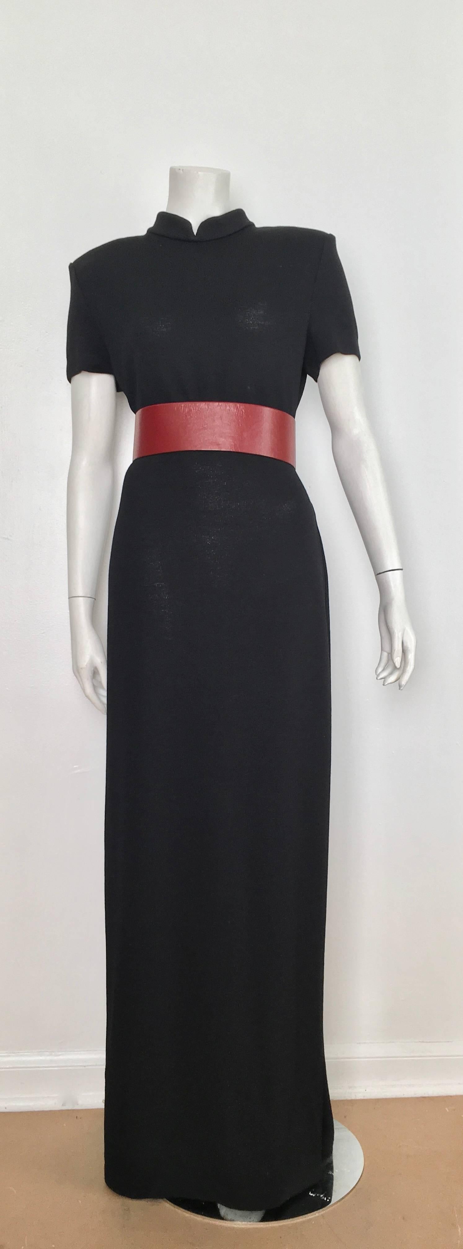St. John black knit short sleeve maxi evening dress with cutout band around waistline is a size 10.  This ultra contemporary & sophisticated maxi dress with the cutout square pattern around waistline can be sexy or you can slap a wide Geoffrey Beene