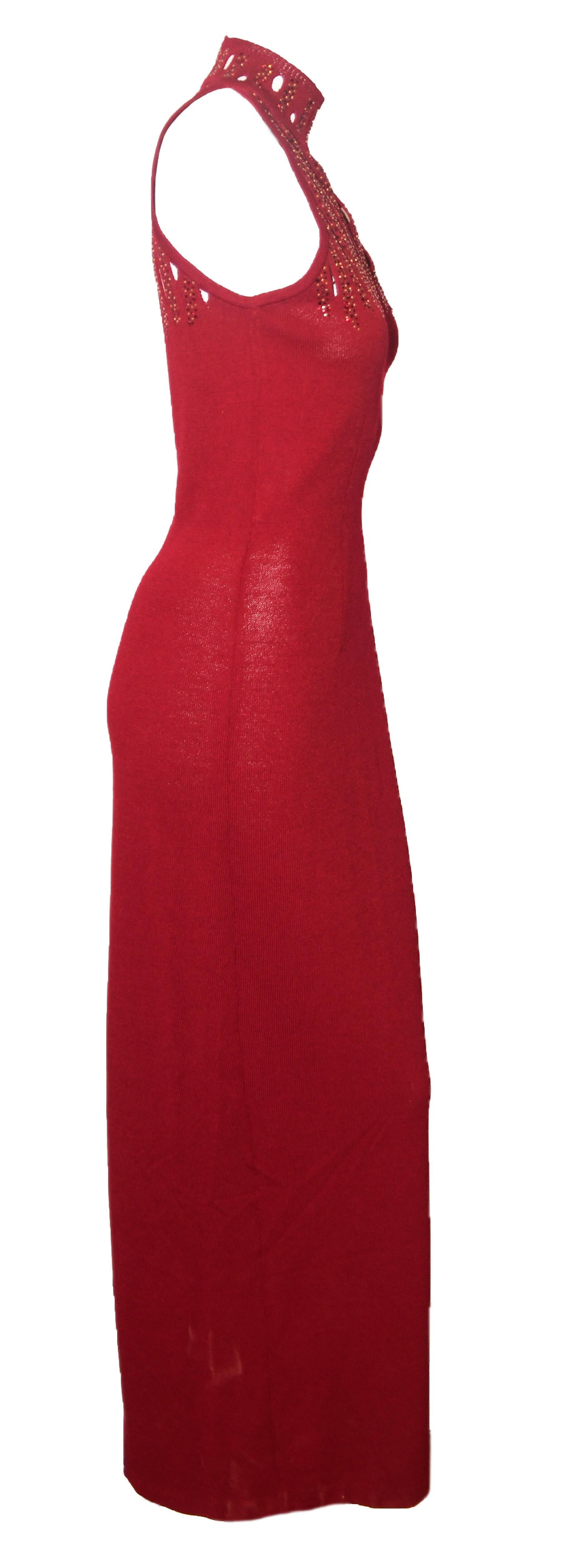 St. John burgundy long evening gown decorated with glimmering red and gold tone crystals, on the bodice, with peek a boo slits.  This knit dress is sleeveless and unlined.  For closure, a hidden zipper at back, also, a vent at back.  This garment is