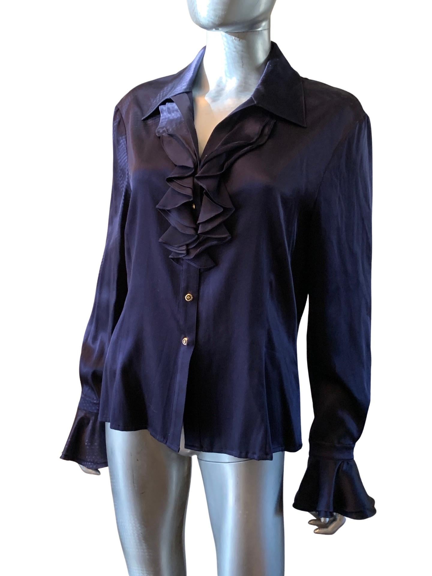 A very chic St. John silk charmeuse blouse In the most beautiful shade of navy. The blouse has a slight V-neck with ruffled flounces on the side and beautiful ruffled cuffs. The blouse obtains the original signature St. John buttons. Size 10. New