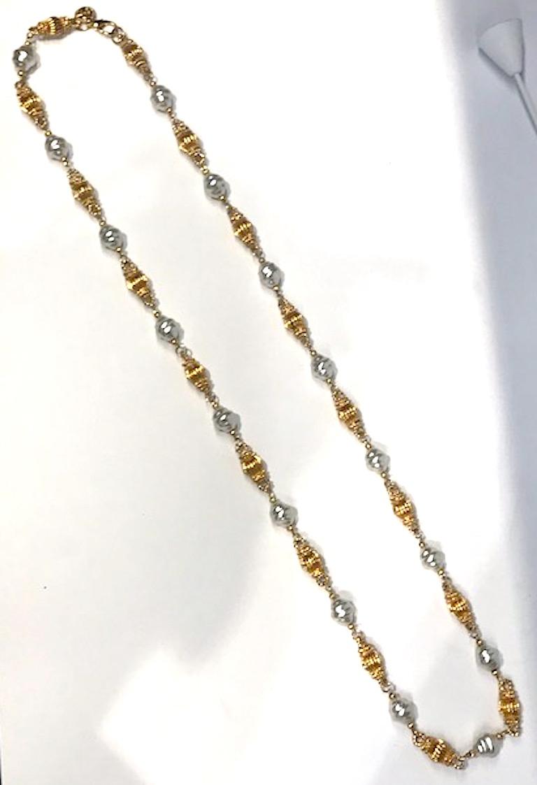 An elegant beautifully made St. John necklace of ribbed gold links alternating with faux baroque pearl beads. The total length is 43 inches. The faux Baroque pearls are oval in shape, .5 of an inch wide, .68 of an inch long and finished on each end