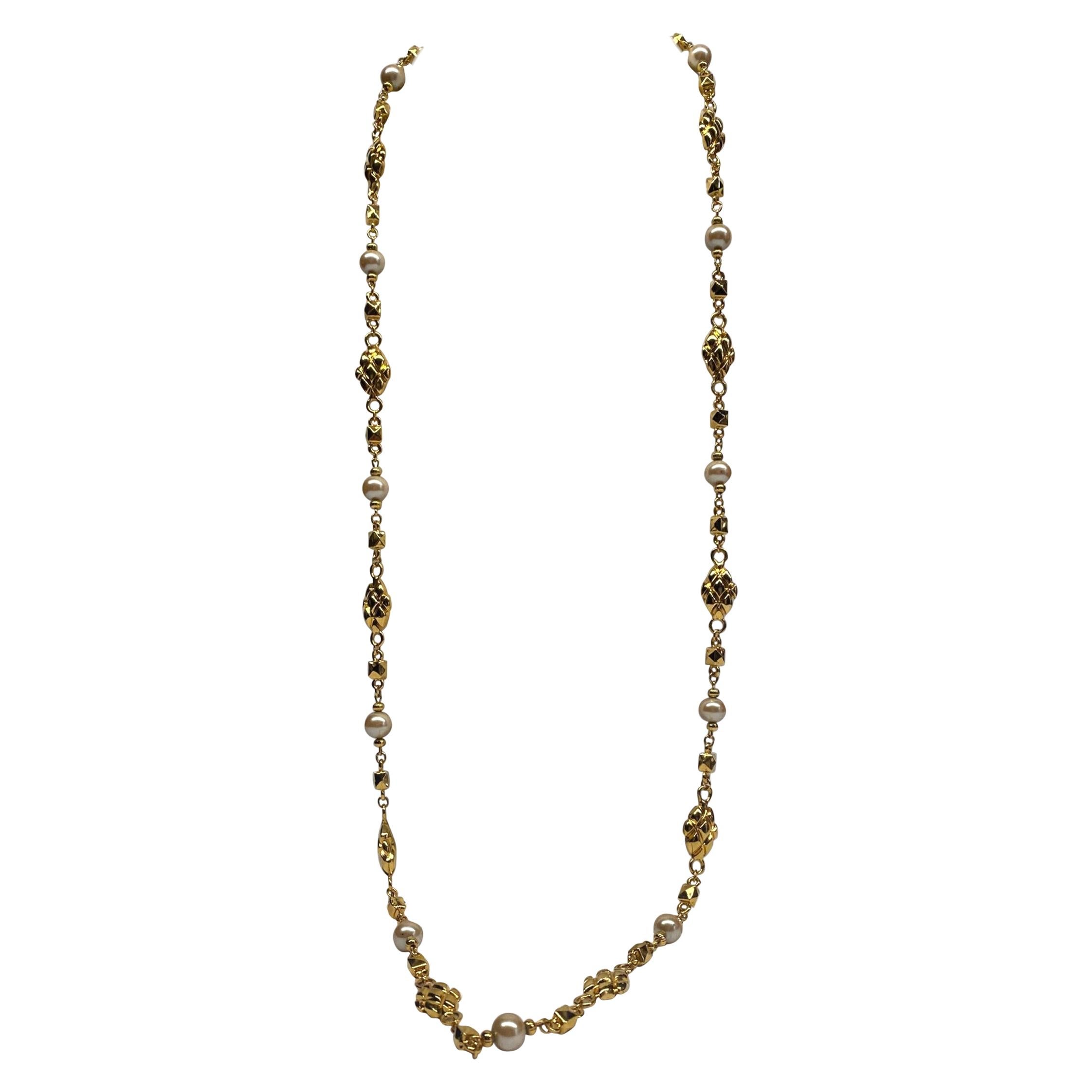 An elegant beautifully made St. John gold plate necklace with faux pearl beads. It is comprised of small faceted cube links and oval quilted textured links with faux pearl accent beads. The pearl beads are 10 mm in size while the quilt links are .5 