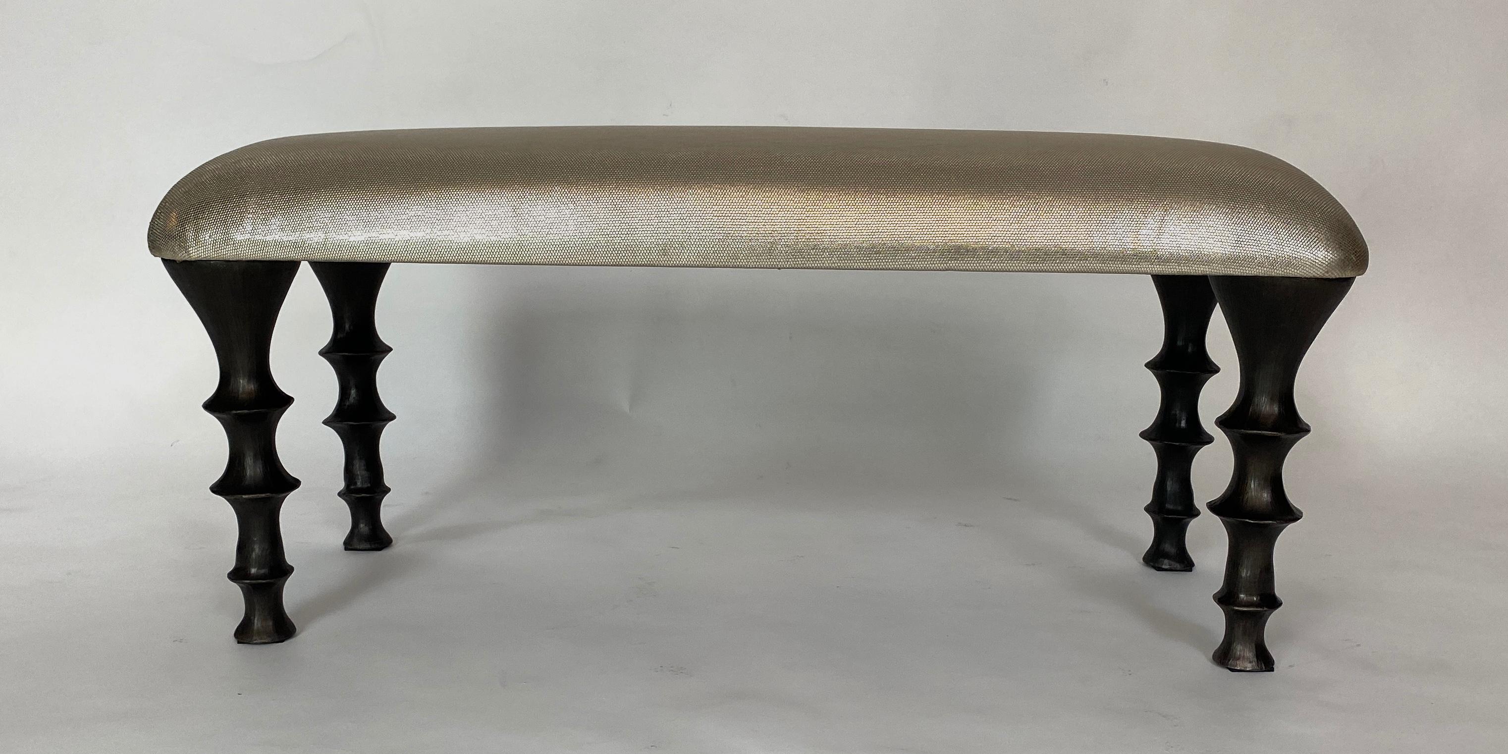 Banc polyvalent avec des pieds en bronze siliconé moulé et un coussin en peau de vache métallique gaufrée. Le design des pieds présente une texture organique. Ce banc fera une entrée remarquée dans votre
intérieur. Les bancs peuvent également être