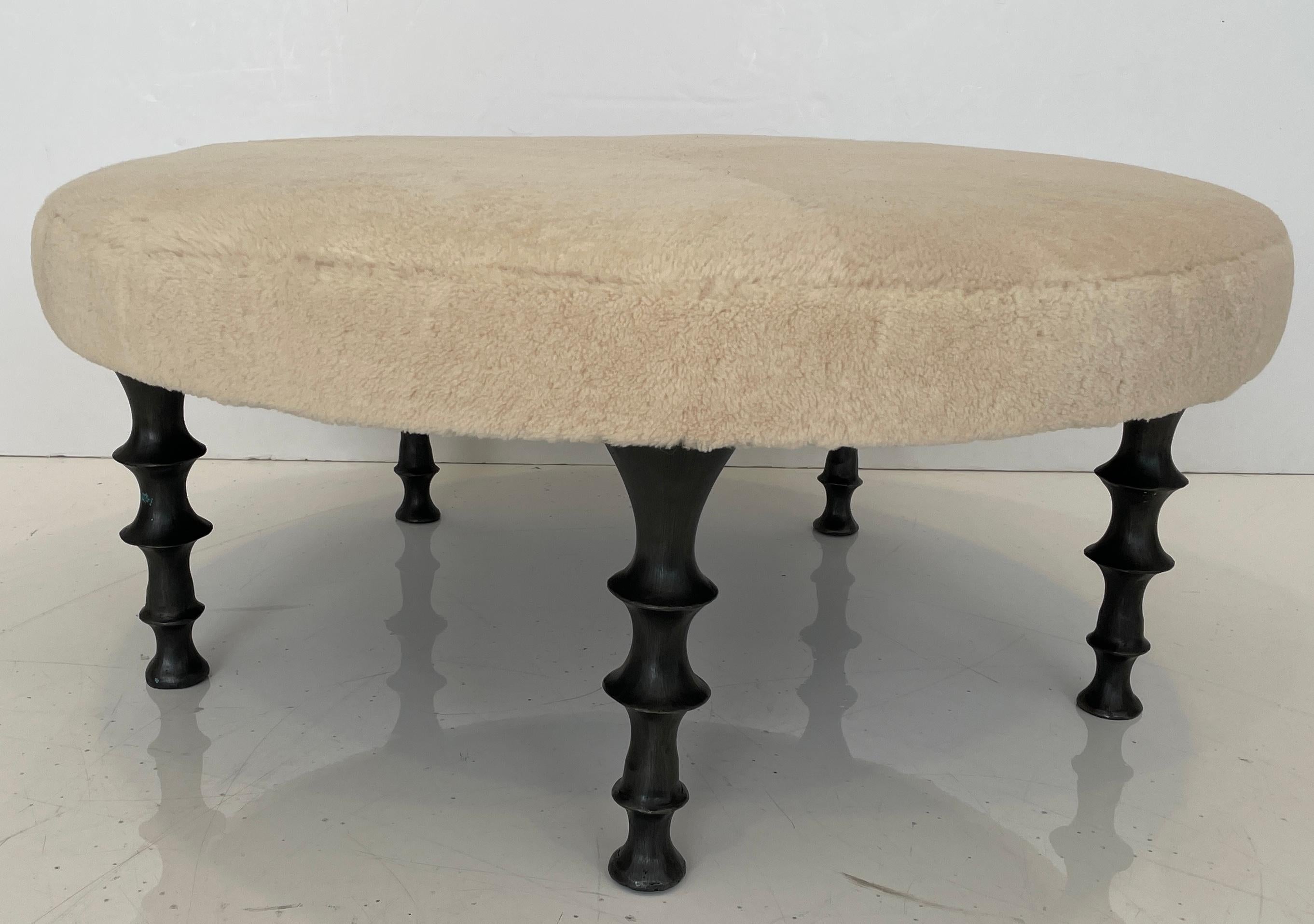 This round ottoman make a dramatic statement in your interior. It has five powerful cast silicon bronze legs, shearling hide with an organic feel. The cushion can be made is various shapes, in your own fabric or hide. We can also create stools or