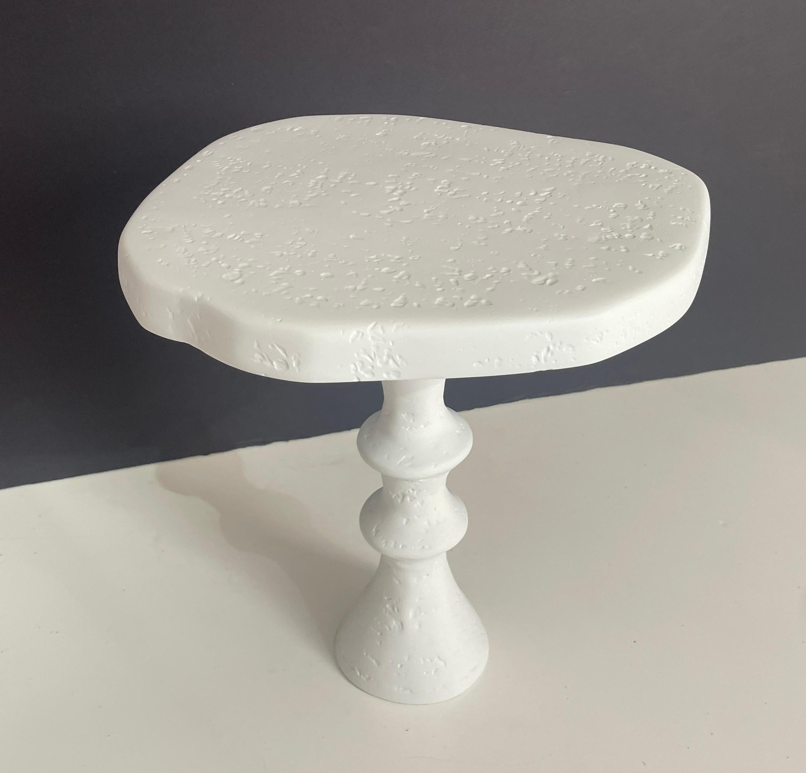 Organic in shape, this plaster side table with its pedestal base is a unique piece and very versatile. This smelled scale side table works well in both traditional and modern interiors. The handcrafted plaster is beautiful in its natural white