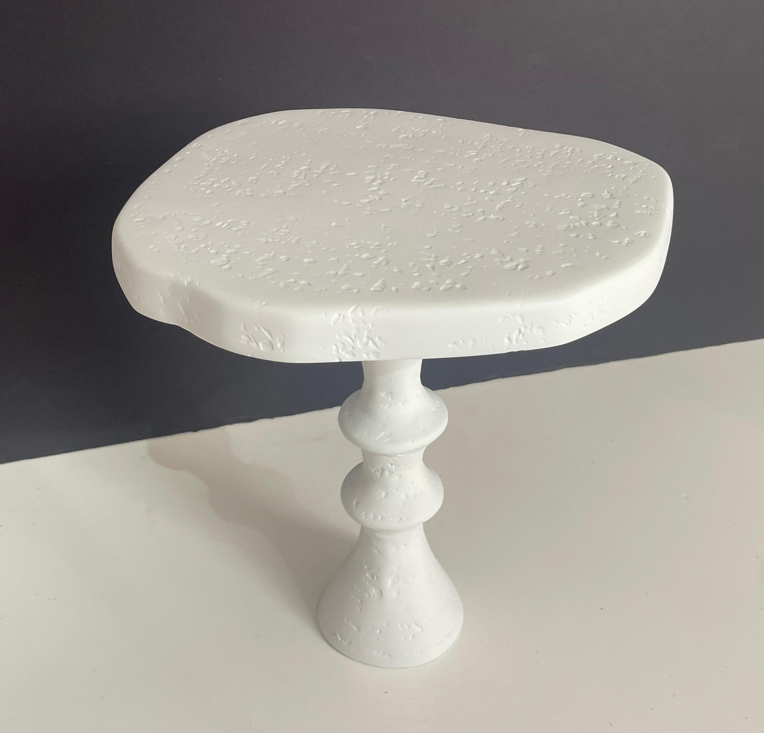 De forma orgánica, esta mesa auxiliar de escayola con base de pedestal es una pieza única y muy versátil. Esta mesa auxiliar de escala olfativa queda bien tanto en interiores tradicionales como modernos. El yeso artesanal es precioso en su acabado