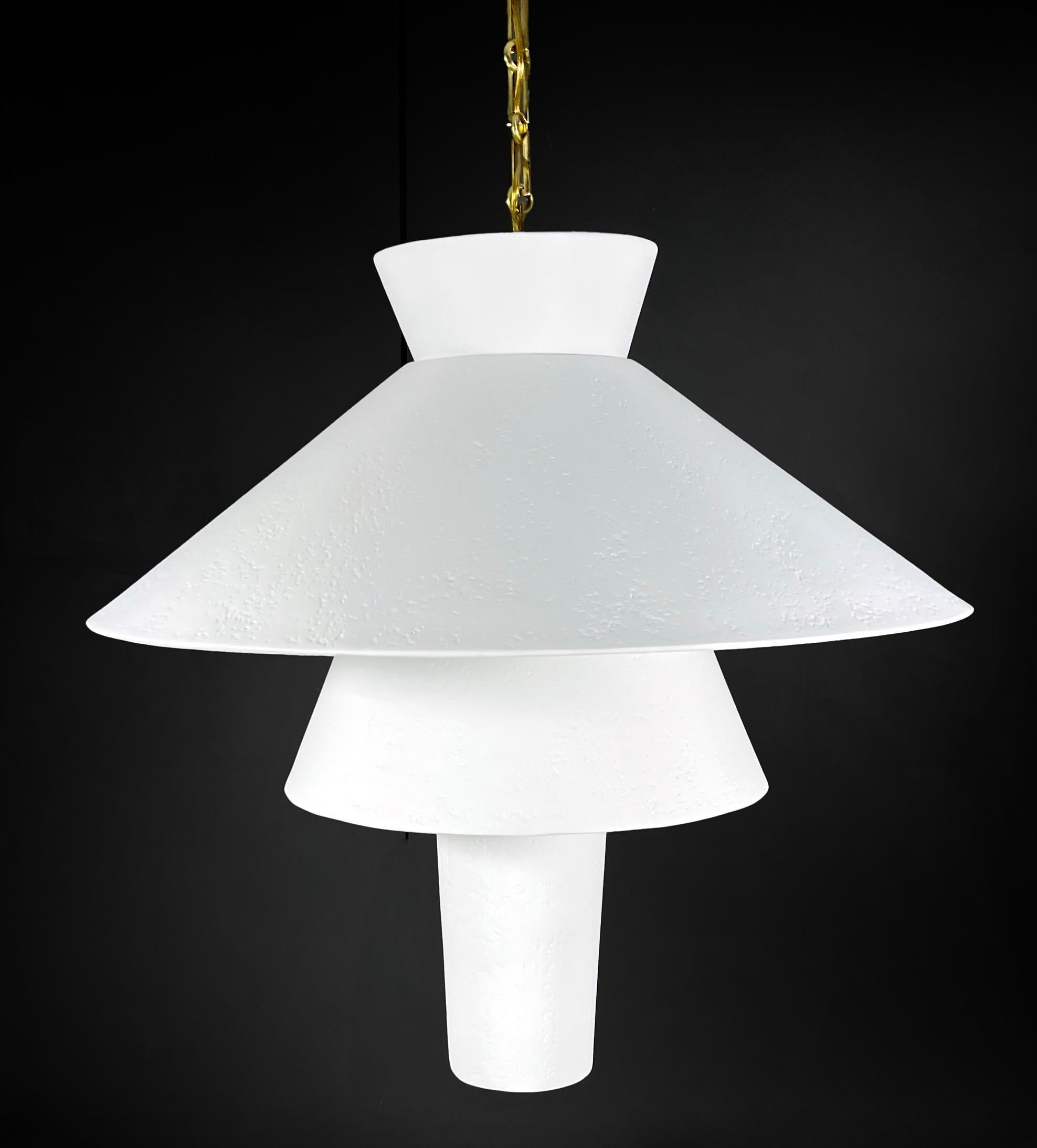 A sculptural statement in plaster and brass, the St Sulpice Chandelier features a tiered, geometric form that casts both uplight and downlight for dramatic effect. Hand-finished in plaster of Paris, its subtly textured surface adds quiet