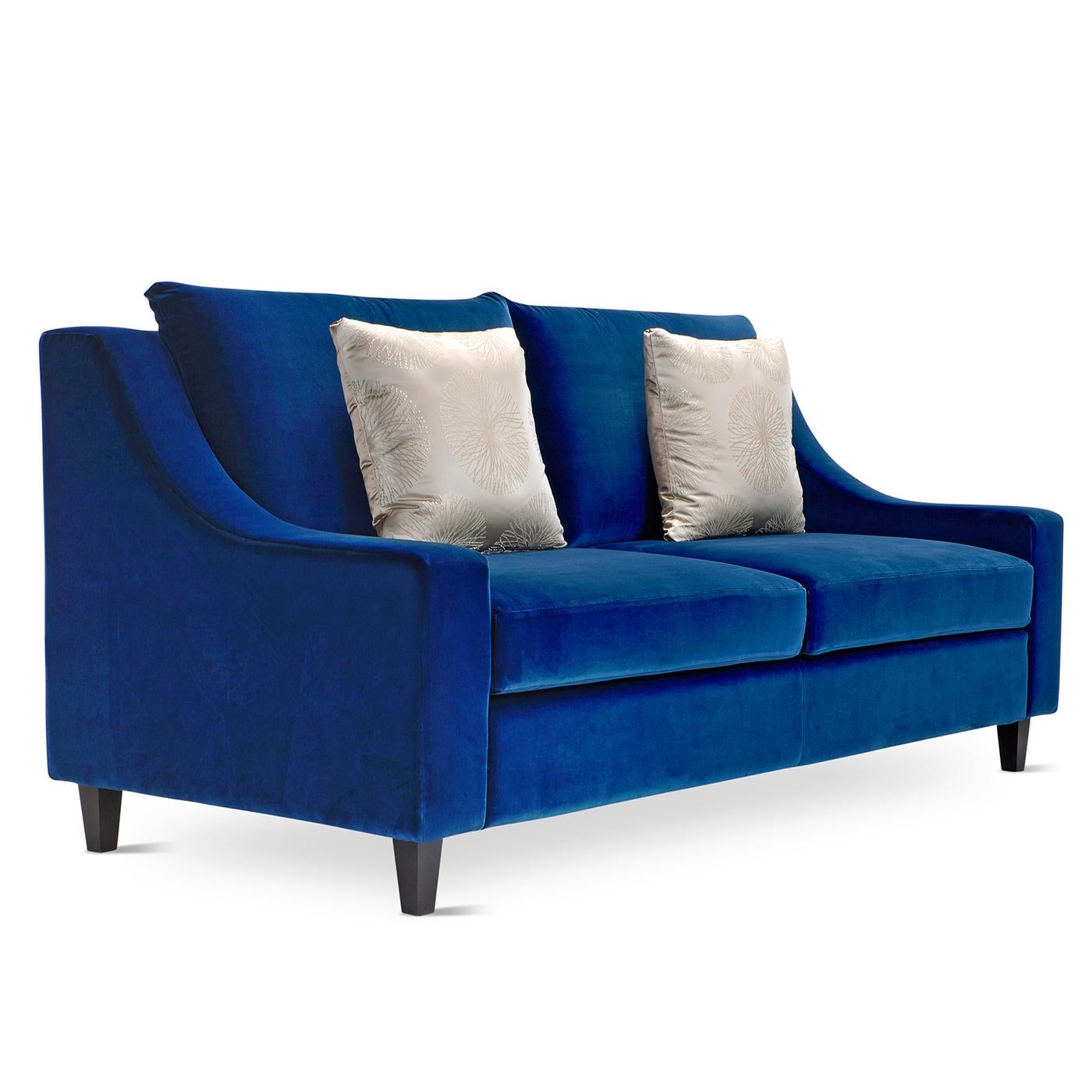 Marked by a vibrant cobalt blue Dacron upholstery and a classic silhouette, this sofa exudes comfort and style. The tapered armrests form a well-balanced unit with the platform base, while the multi-density polyurethane padding of seat and back