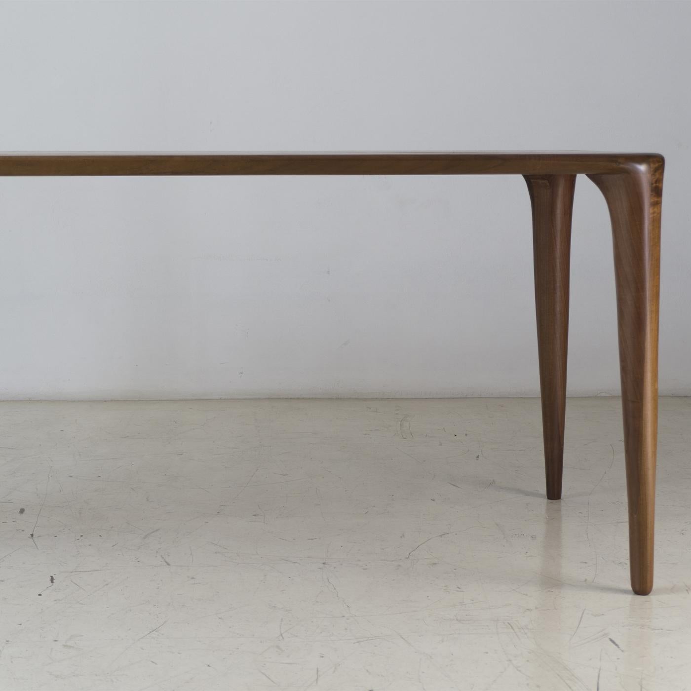 Truly one of a kind, this table is part of the S collection, characterized by smooth surfaces, gentle curves and the elegant joints between the table's legs and top. Crafted in the best solid Italian blonde walnut on the market, the table is further