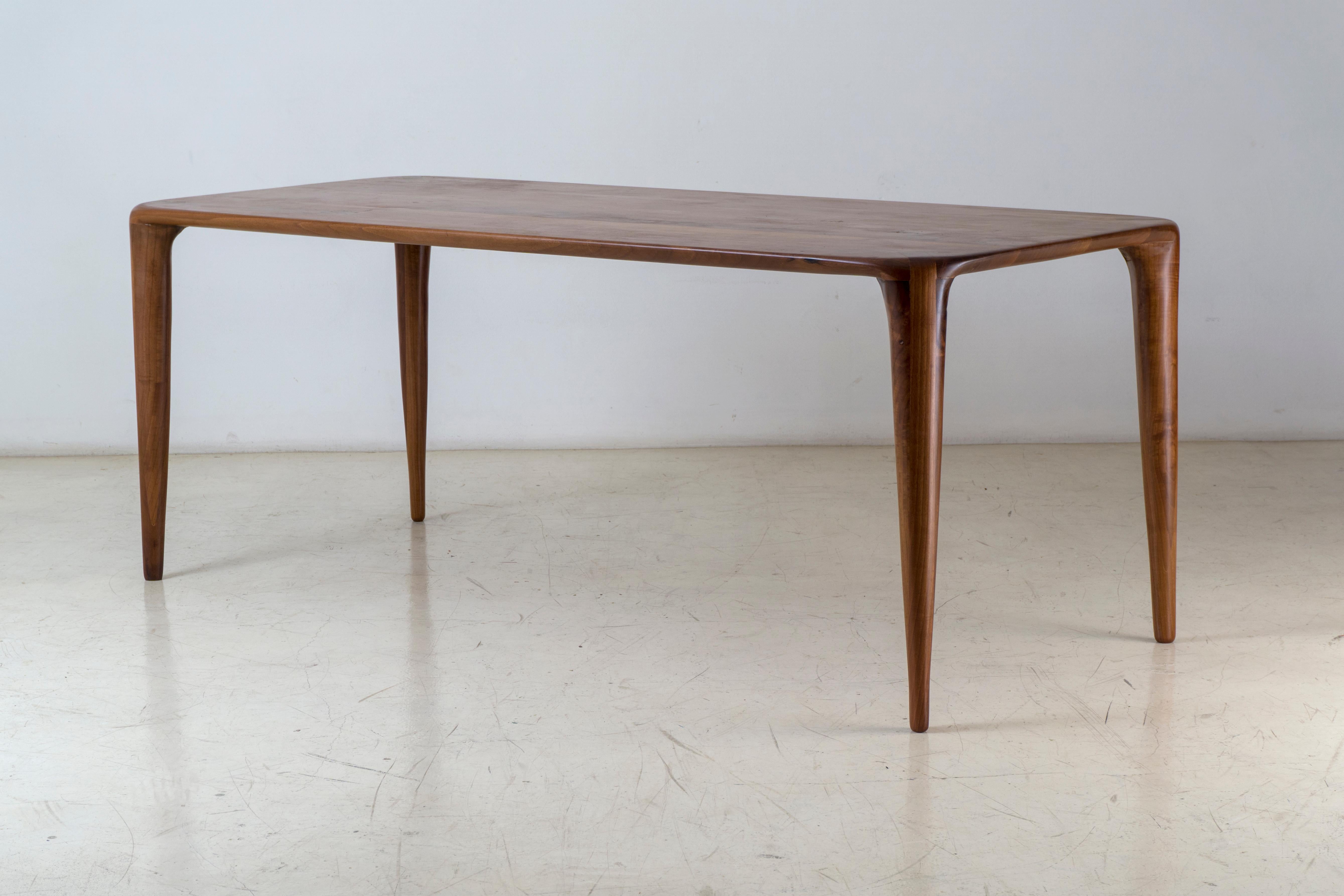 This is the S_dining table designed and handcrafted by Tommaso Garavini. It's made of solid Italian Walnut, and it has been created using no screws. 
S_ stands for Sensuality which was the main inspiration that leaded the creation of this unique