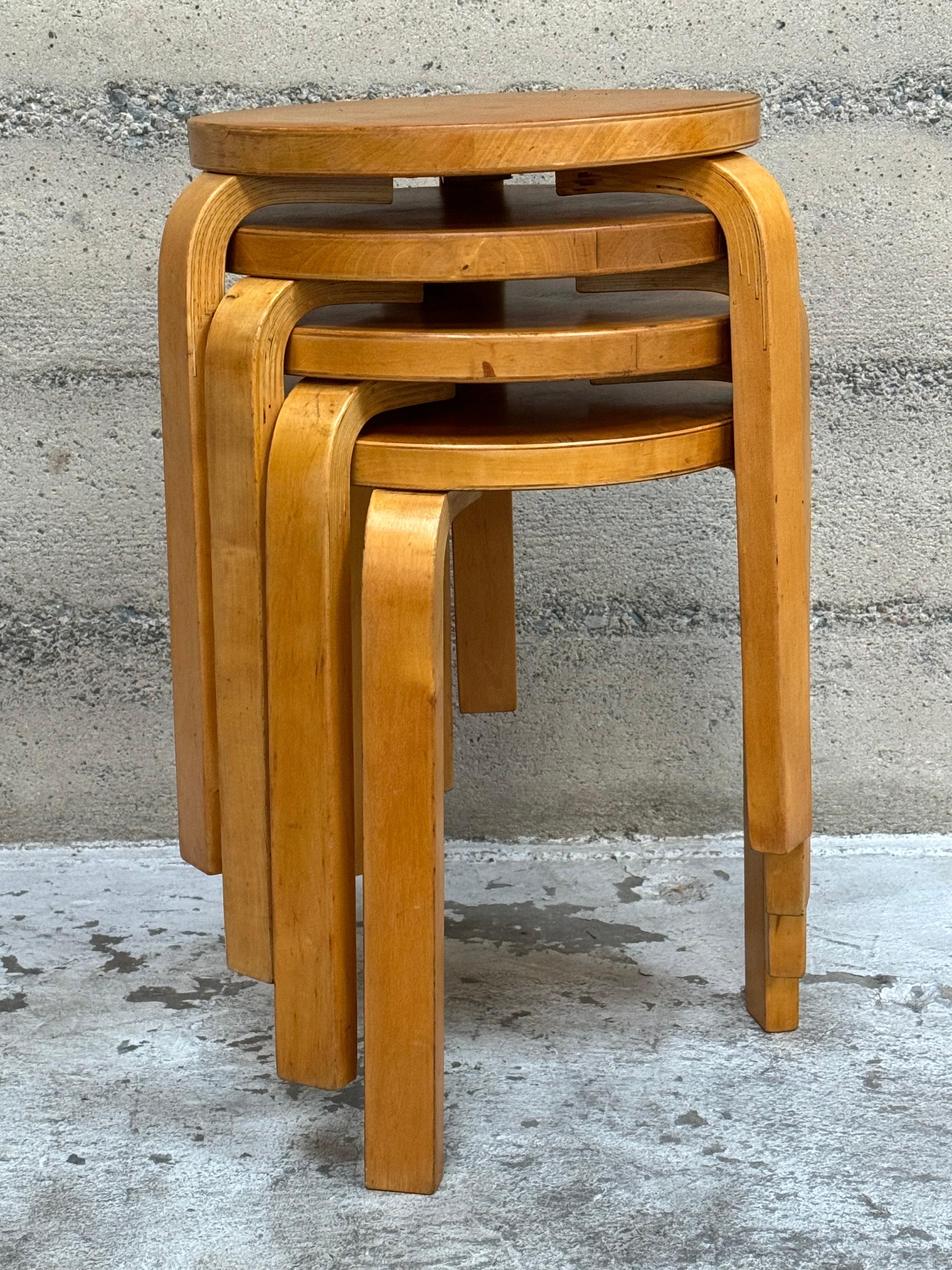 Set of four Alvar Aalto stool model 60, crafted out birch with lamented and steam bent legs. Nice patina with a golden color to the wood and lacquer, each marked on the bottom. A nice set of all original condition stools with a total height of 24