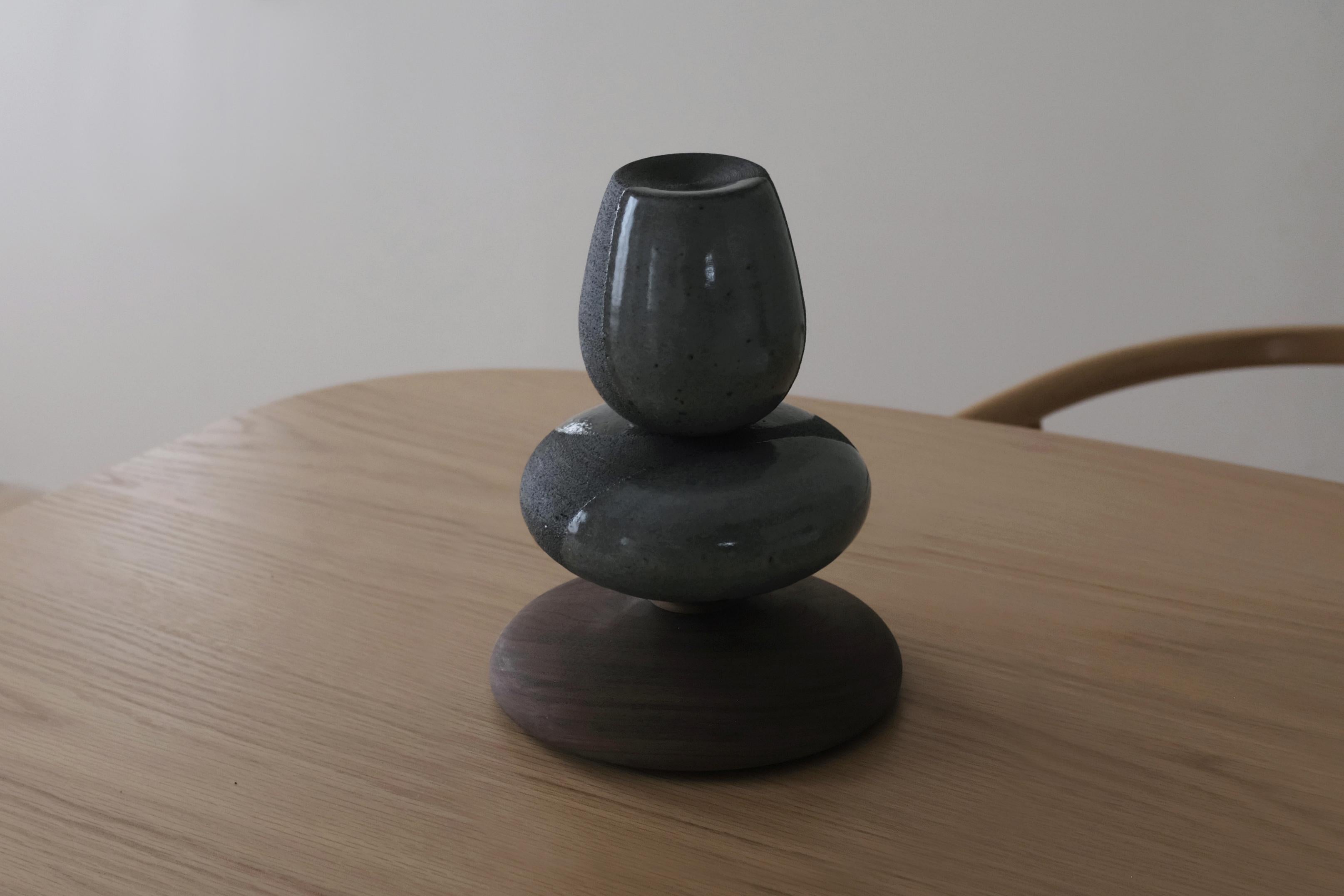 Stack Sculpture is a small table sculpture in a dark stoneware with celadon glaze, on a walnut wooden base. These small stack sculptures are a contemporary iteration of traditional Korean aesthetics by the artist Soo Joo, and they bring a sense of