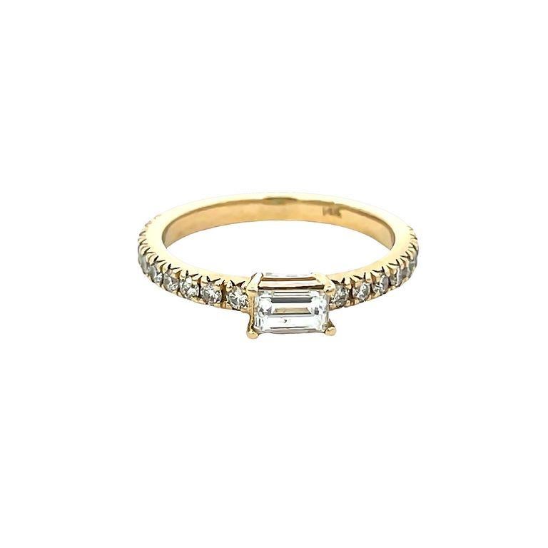 This 14K yellow gold band is designed with one baguette diamond in the center on a four-prong setting in the shank there is one raw white round diamond three-quarters way design with a total weight of 0.79 carats. This unique piece is designed to be