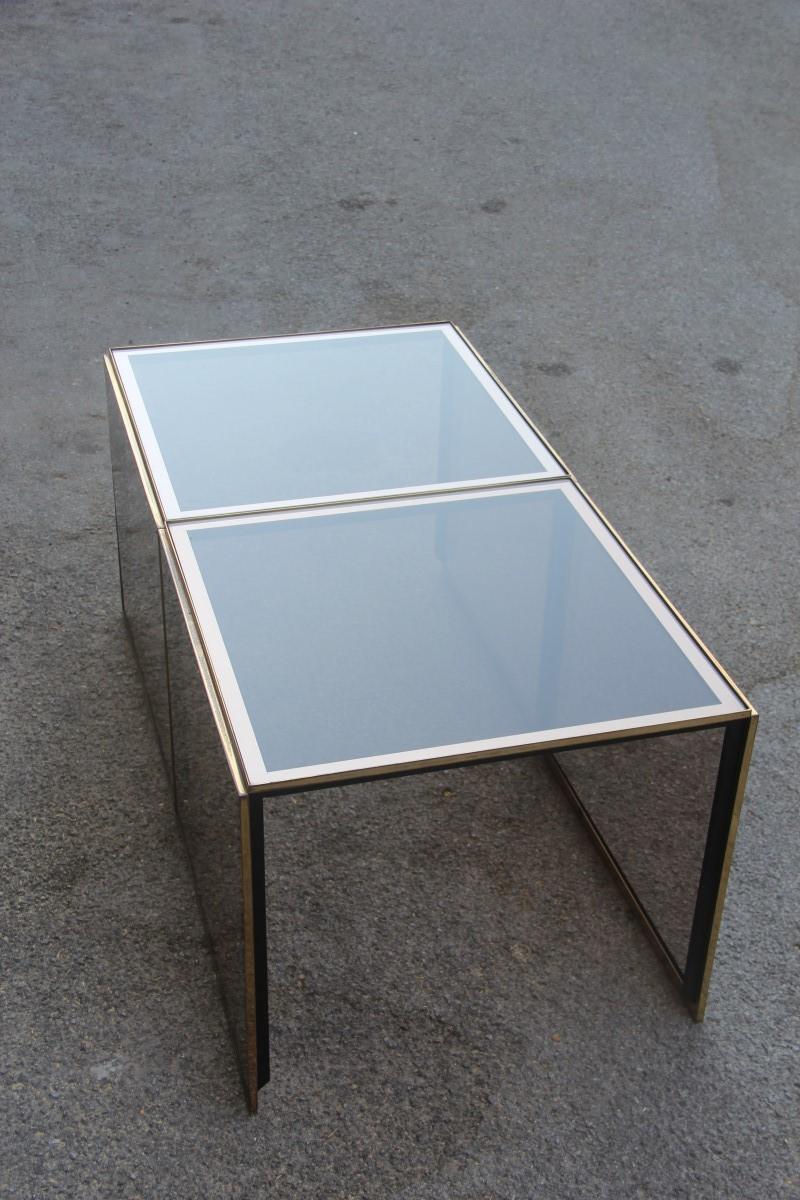 Stackable coffee tables in mirrored golden brass glass with a square shape, 1970s.

These two tables are really interesting, the glass parts are mirrored at the edges, the Minimalist structure in solid brass, the peculiarity that can be stacked in