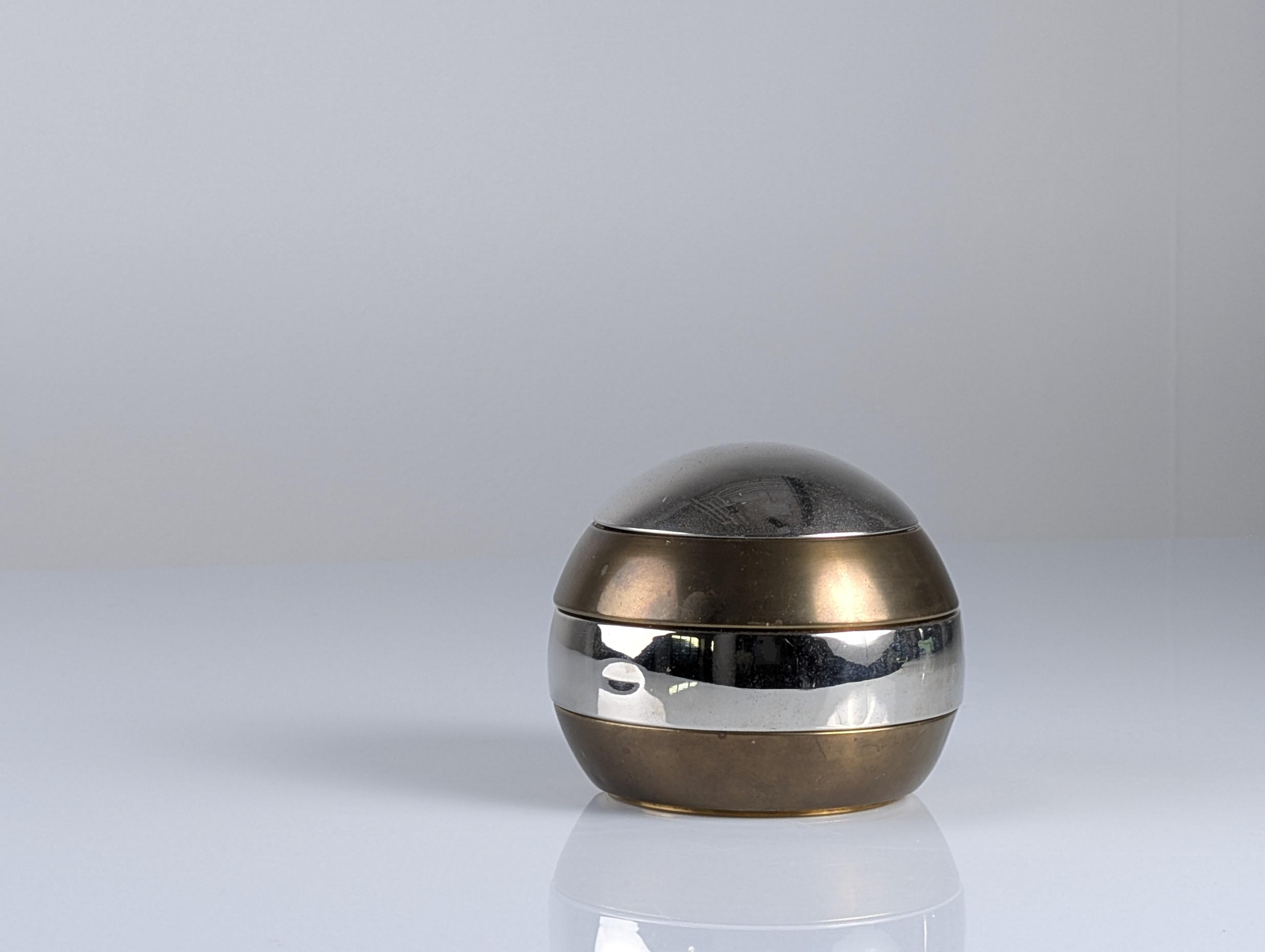 Modular sculpture designed by Tommaso Barbi in the 1970s, composed of four stackable brass and chrome pieces that fit precisely to form an elegant sphere. Its design embodies the sophistication of the golden age of Italian design, playing with the