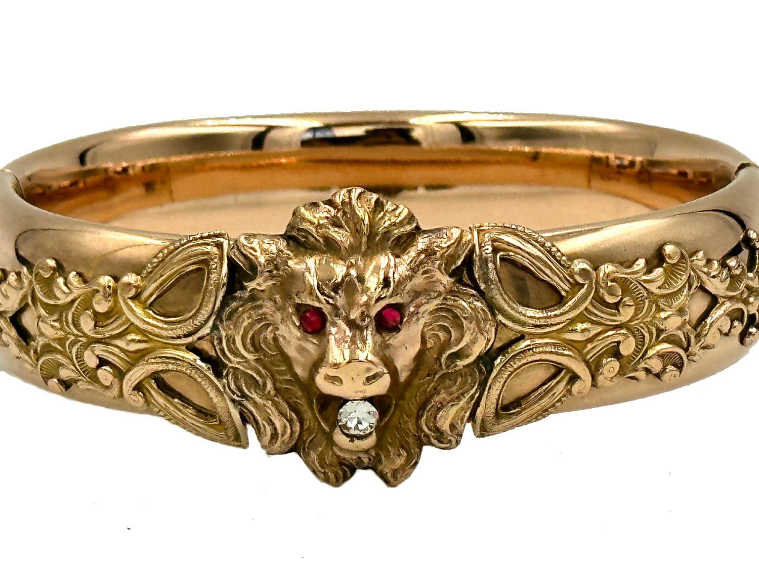 What a beautiful lion bangle!  Ornate wirework extends outward from a bold, clear central lion.  Ruby colored paste stones form the eyes while a clear paste stone or mine diamond form the super sparkly stone in the mouth.  Additional decoration