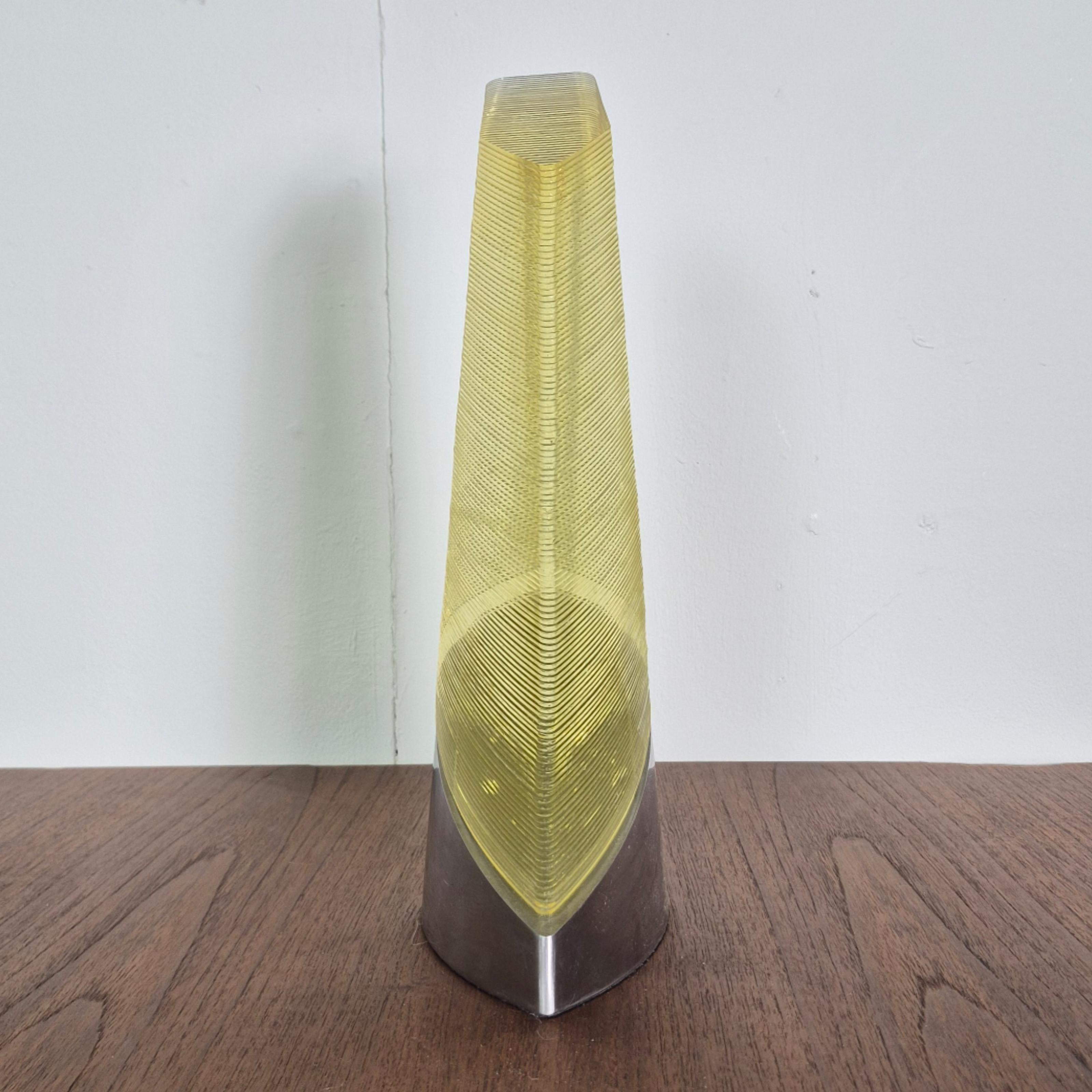 Unusual abstract sculpture. Made from stacked sheets of amber glass. It is mounted on a metal base that follows the contours of the glass shape.
Well made piece of art that will draw your eye to it. Especially when the light hits the object. From