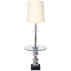 Lampada da terra con base a globi cromati impilati e tavolo laterale di vetro