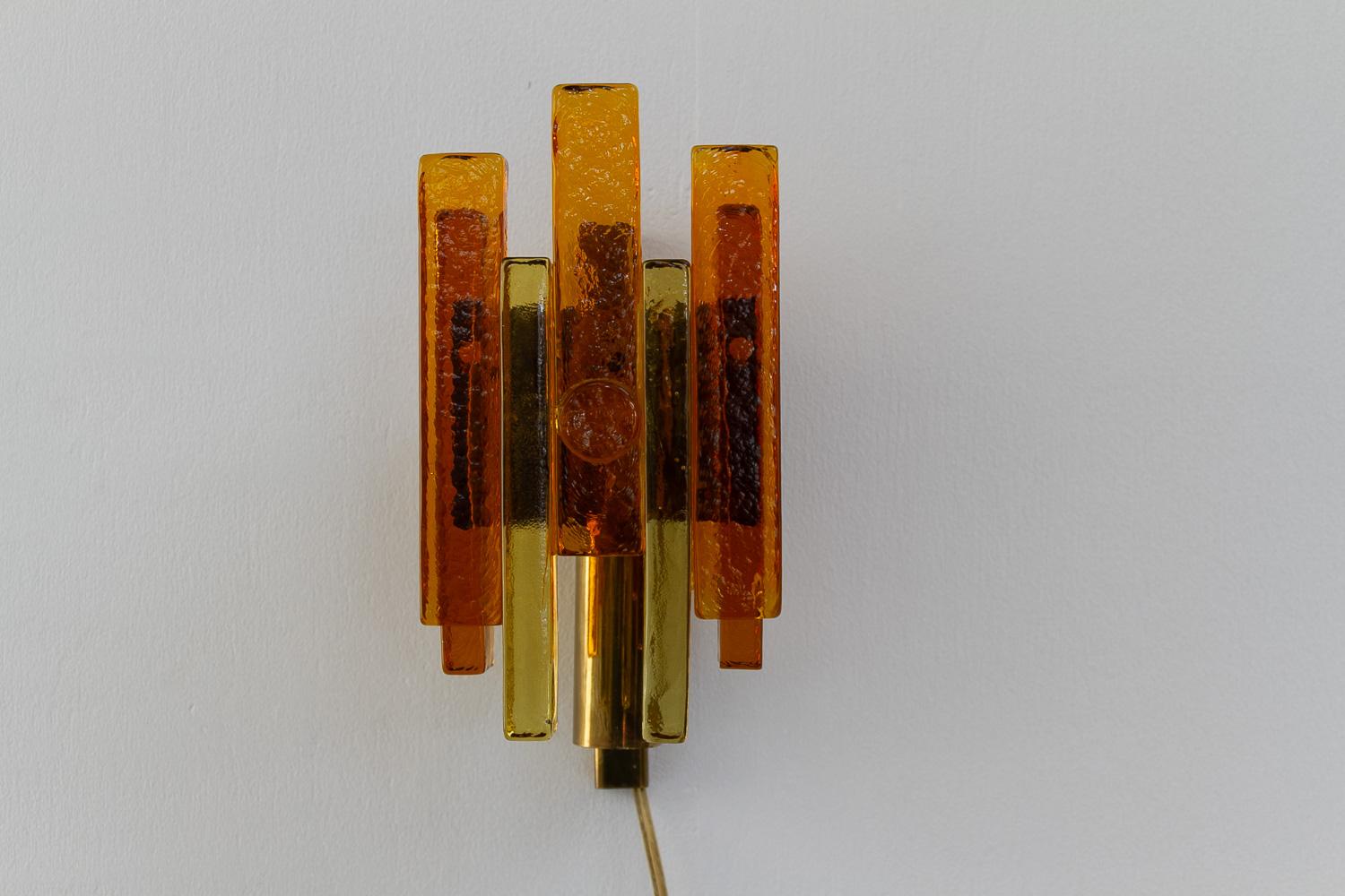 Aplique apilado de cristal y latón de Svend Aage Holm Sørensen, década de 1960.

Aplique moderno de mediados de siglo de cristal color ámbar y dorado. Esta lámpara rústica de pared fue diseñada por Svend Aage Holm Sørensen y fabricada por Hassel &