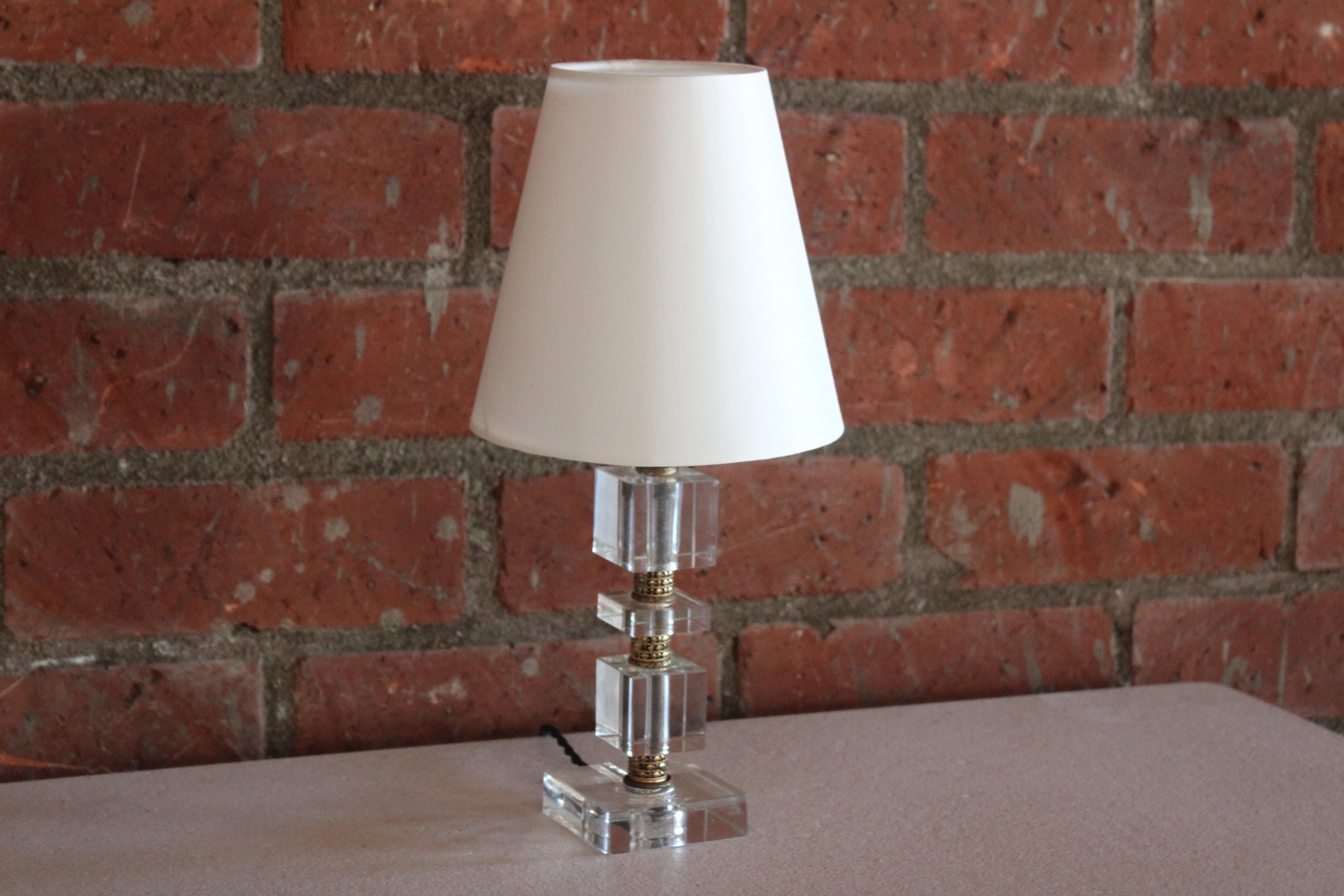 A vintage stacked glass table lamp in the manner of Jacques Adnet. Newly rewired and fitted with a custom shade in silk. Brass accents. One small chip near the bottom of the base.