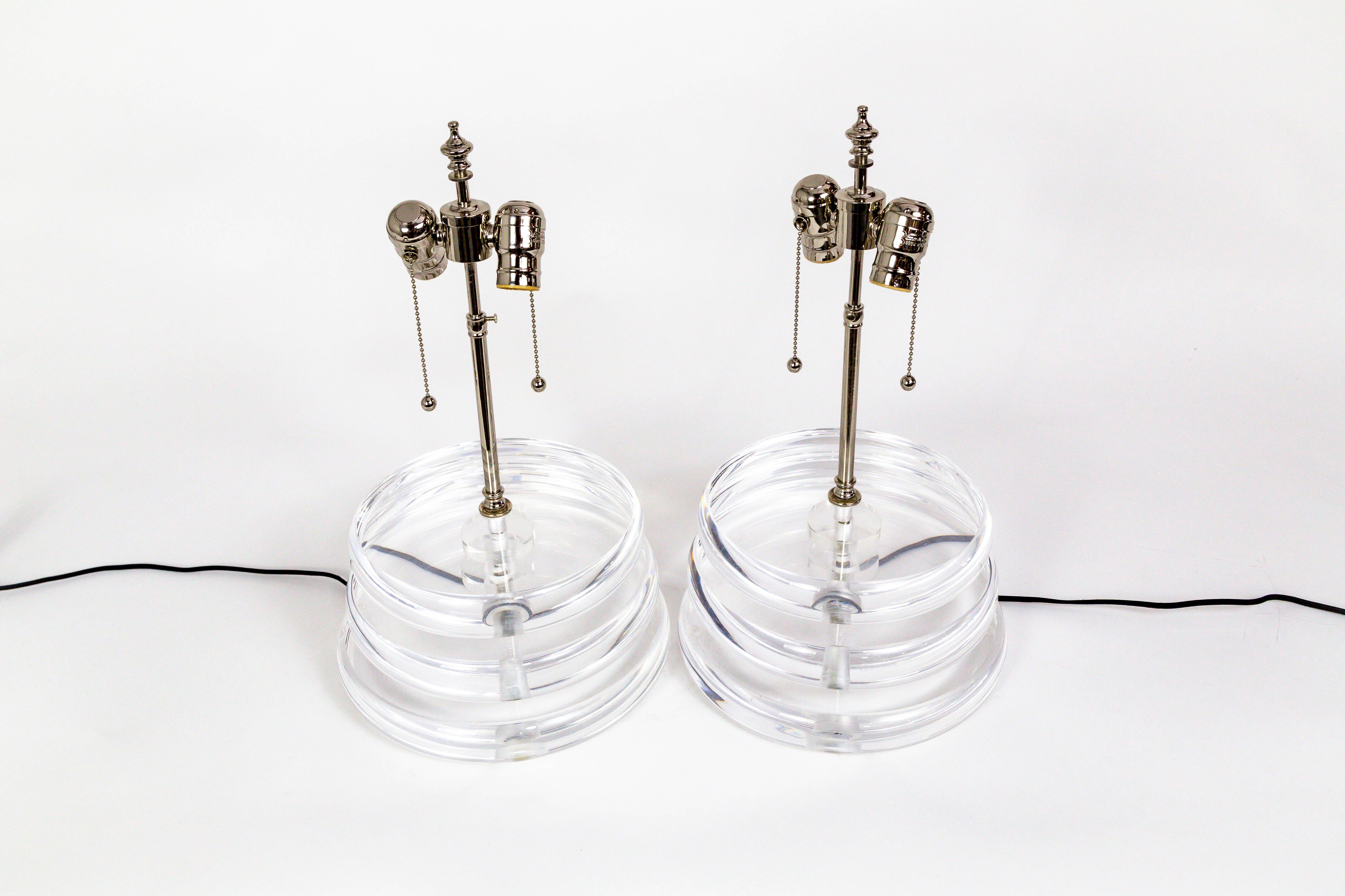 This modish pair of vintage lamps is made of stacked, heavy, Lucite disks that have a very cool magnifying appearance, and sometimes a slight prismatic effect. With chrome hardware and details, 2 swiveling sockets and pullchains, and a black cord.