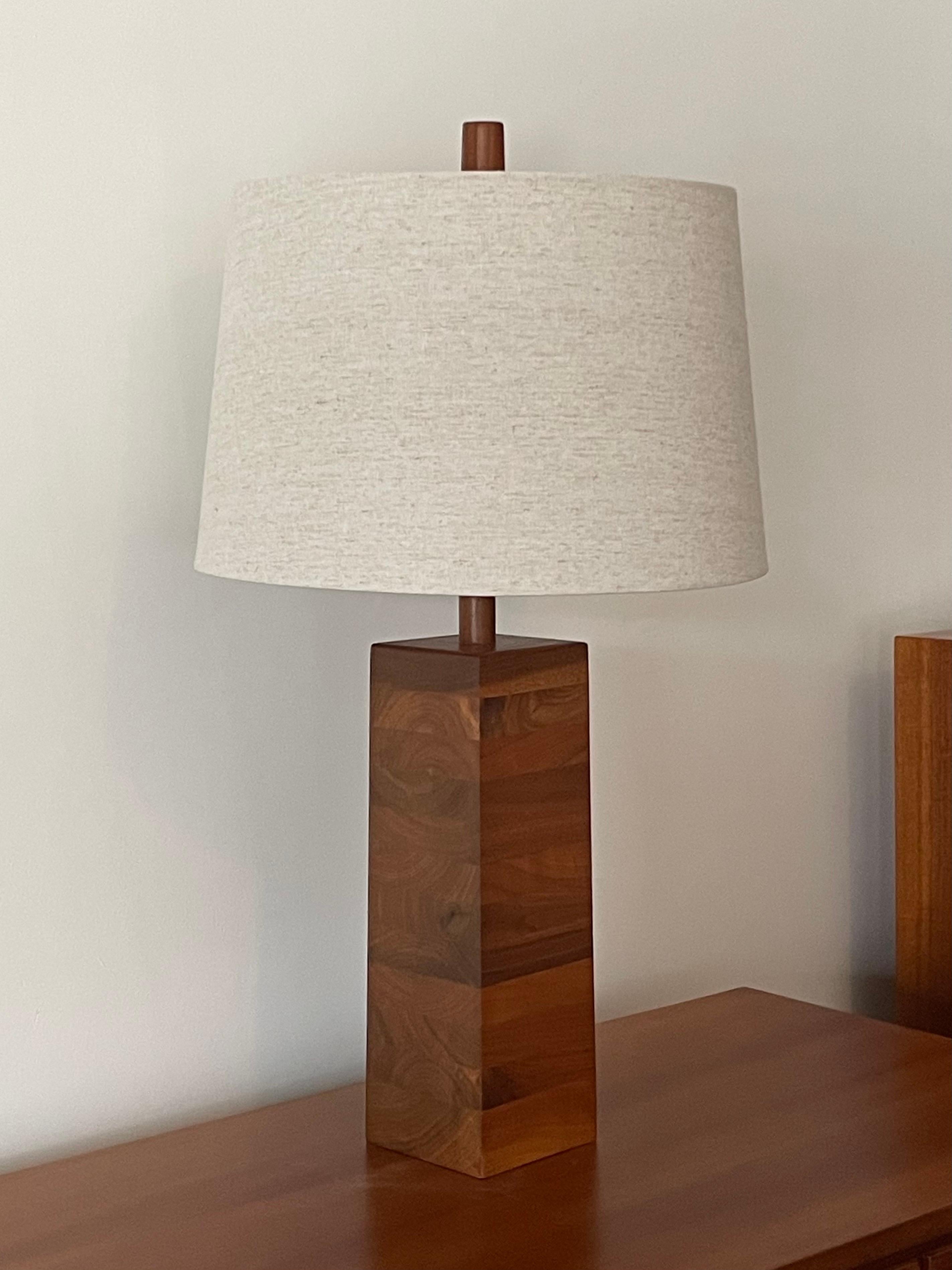 Lampe de table en noyer empilé conçue par les célèbres fabricants de lampes Jane et Gordon Martz. L'incroyable grain du bois crée une forme fluide contre les lignes austères de la lampe. Épi d'origine.

Dimensions générales :
27