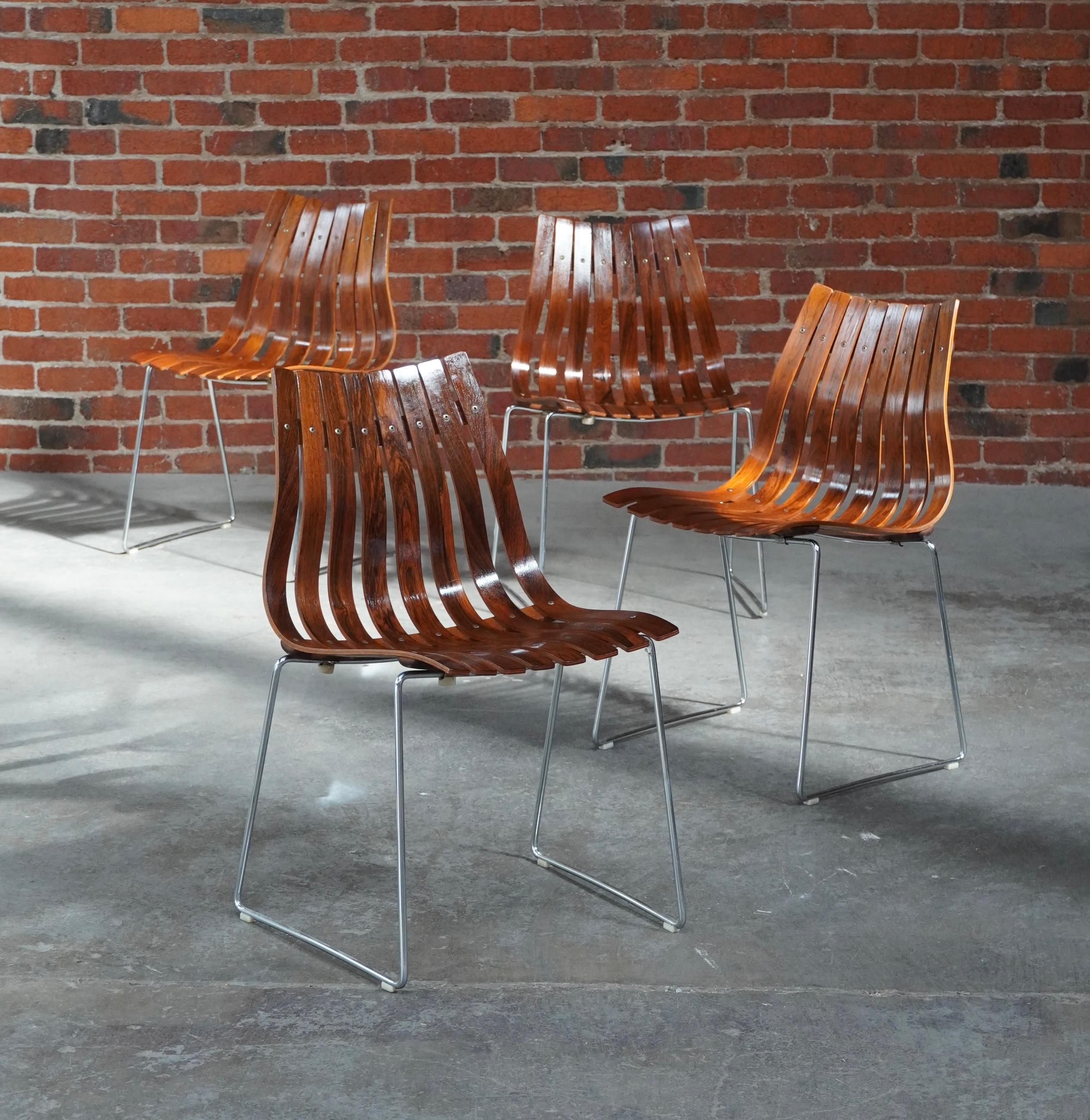 Ensemble de 4 chaises de salle à manger empilables par Hans Brattrud pour Hove Mobler de Norvège. Constitué de sculpturales lattes de bois de rose formées reposant sur un cadre en acier chromé, il est conçu pour s'empiler les unes sur les autres. Le