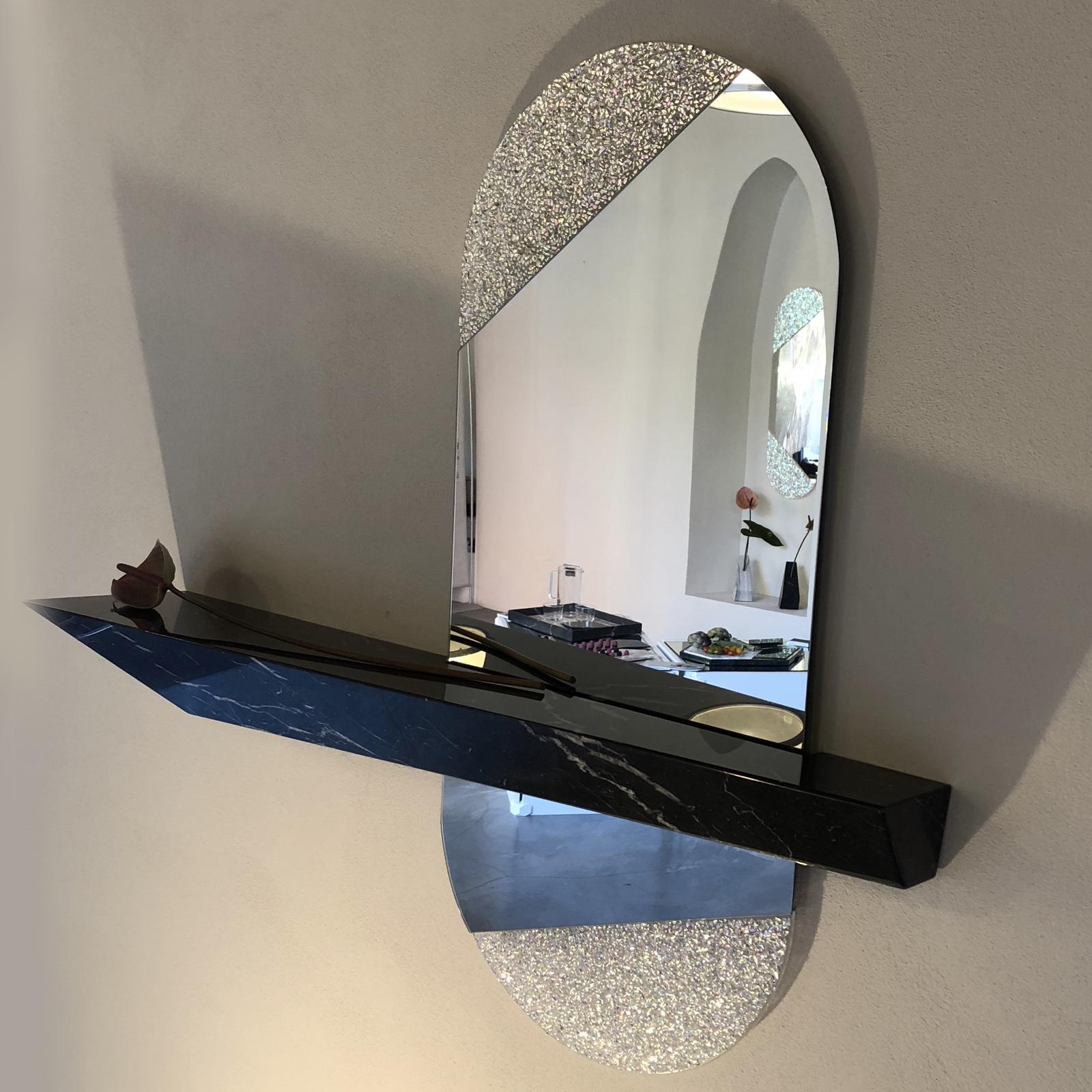 Ce miroir, qui constitue un ajout étonnant à une maison contemporaine, est une pièce accueillante idéale à exposer dans une entrée. Elle présente une tablette en Marquina noire faite à la main avec une finition brillante, en forme de prisme allongé
