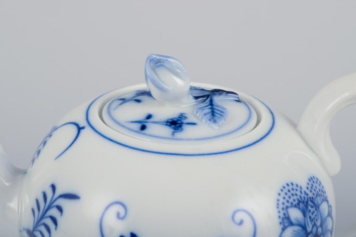 Ciudad de Meissen, Alemania. Tetera pequeña con motivos de Cebolla Azul. 
Tapa con capullo de flor. Pintado a mano.
Aproximadamente de la década de 1930.
Marcado.
Perfecto estado.
Dimensiones: L 16,0 cm x A 10,0 cm.