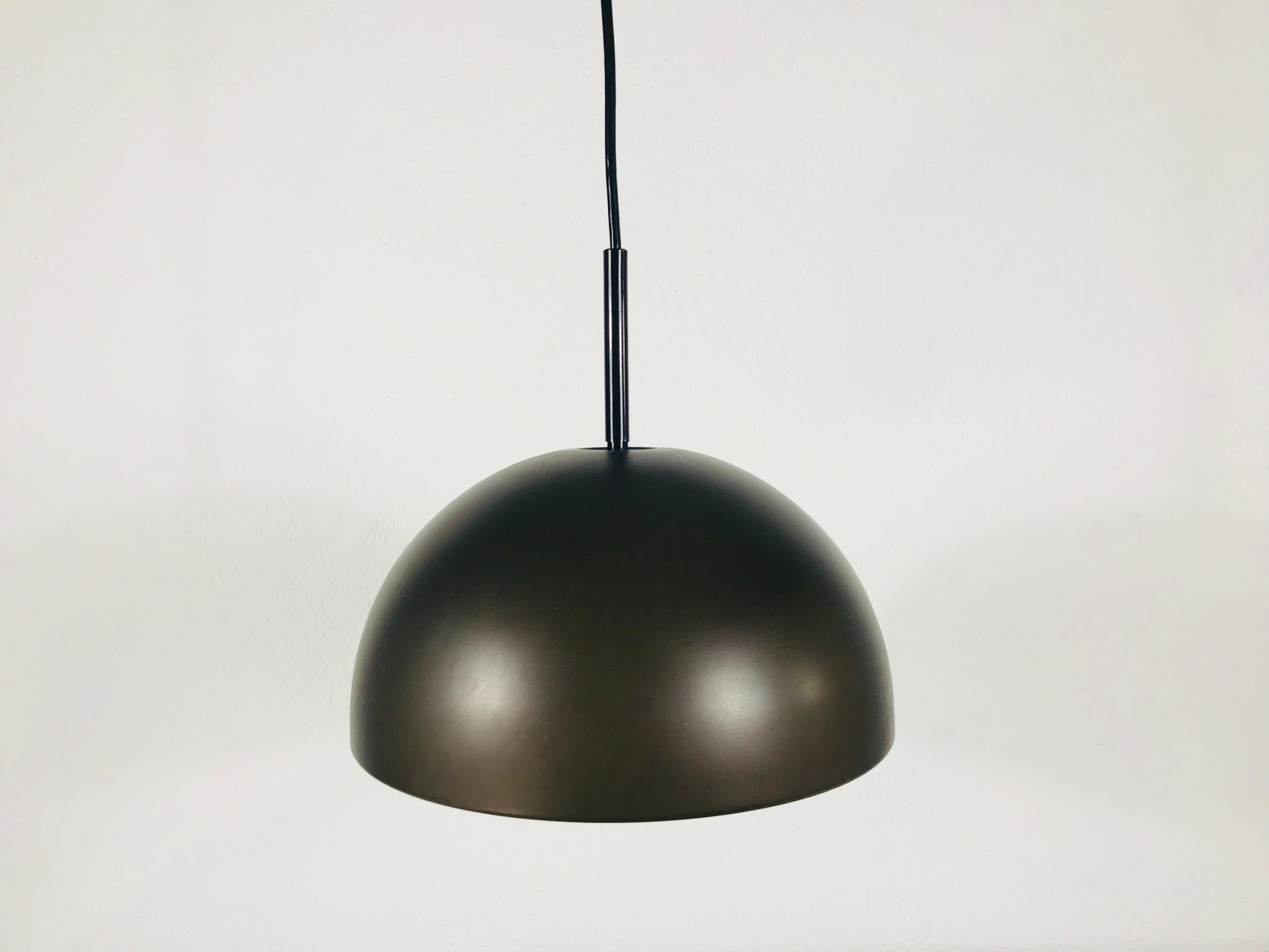 Lampe à suspension marron Staff fabriquée en Allemagne dans les années 1970. L'abat-jour brun est fabriqué en bakélite. Elle est dotée d'un disque rond en plastique blanc qui se fixe au bas de la lampe.

Le luminaire nécessite une ampoule E27.