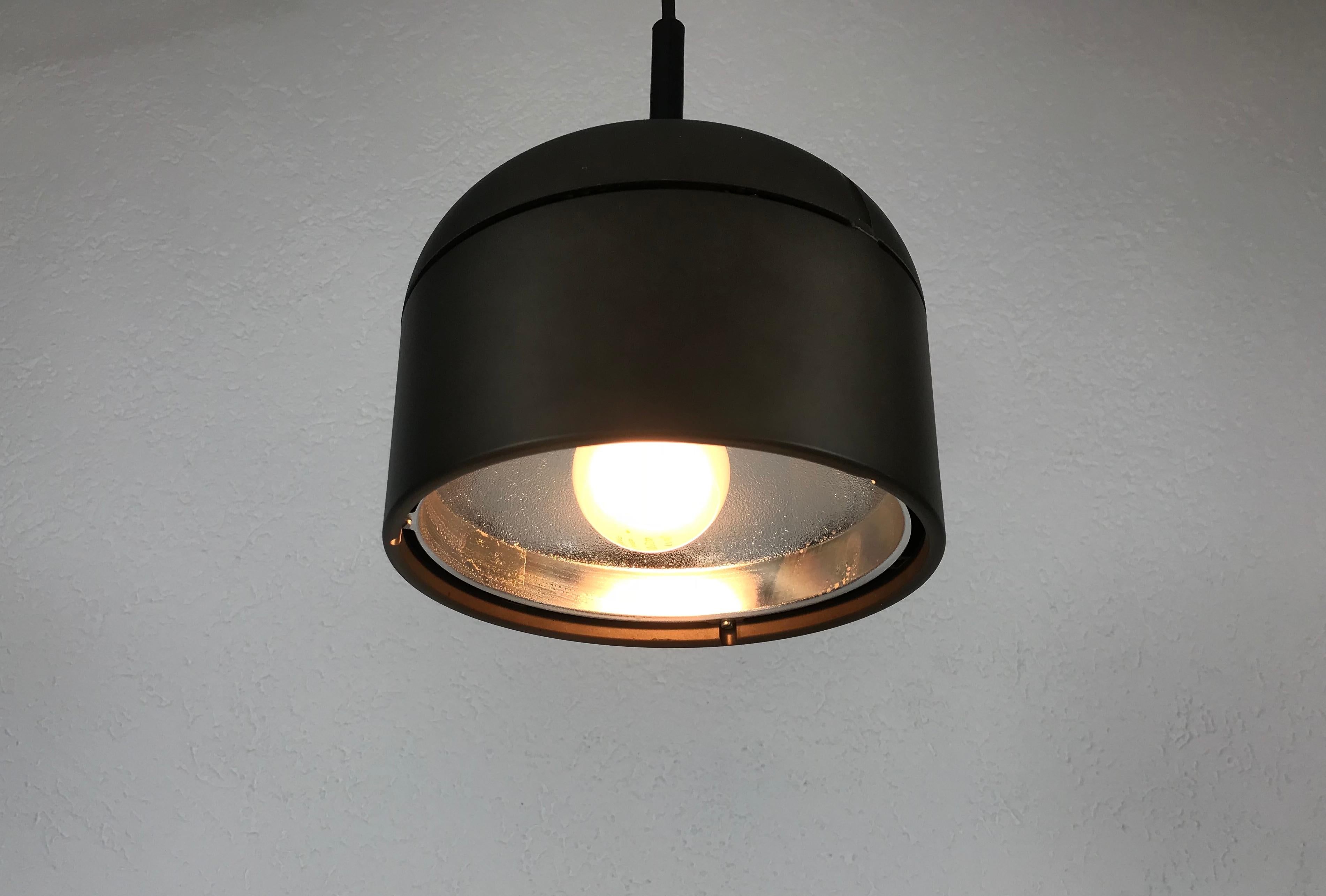 Lampe à suspension marron Staff fabriquée en Allemagne dans les années 1970. L'abat-jour brun est fabriqué en aluminium. 

Le luminaire nécessite une ampoule E27.

La hauteur est réglable jusqu'à 150 cm.