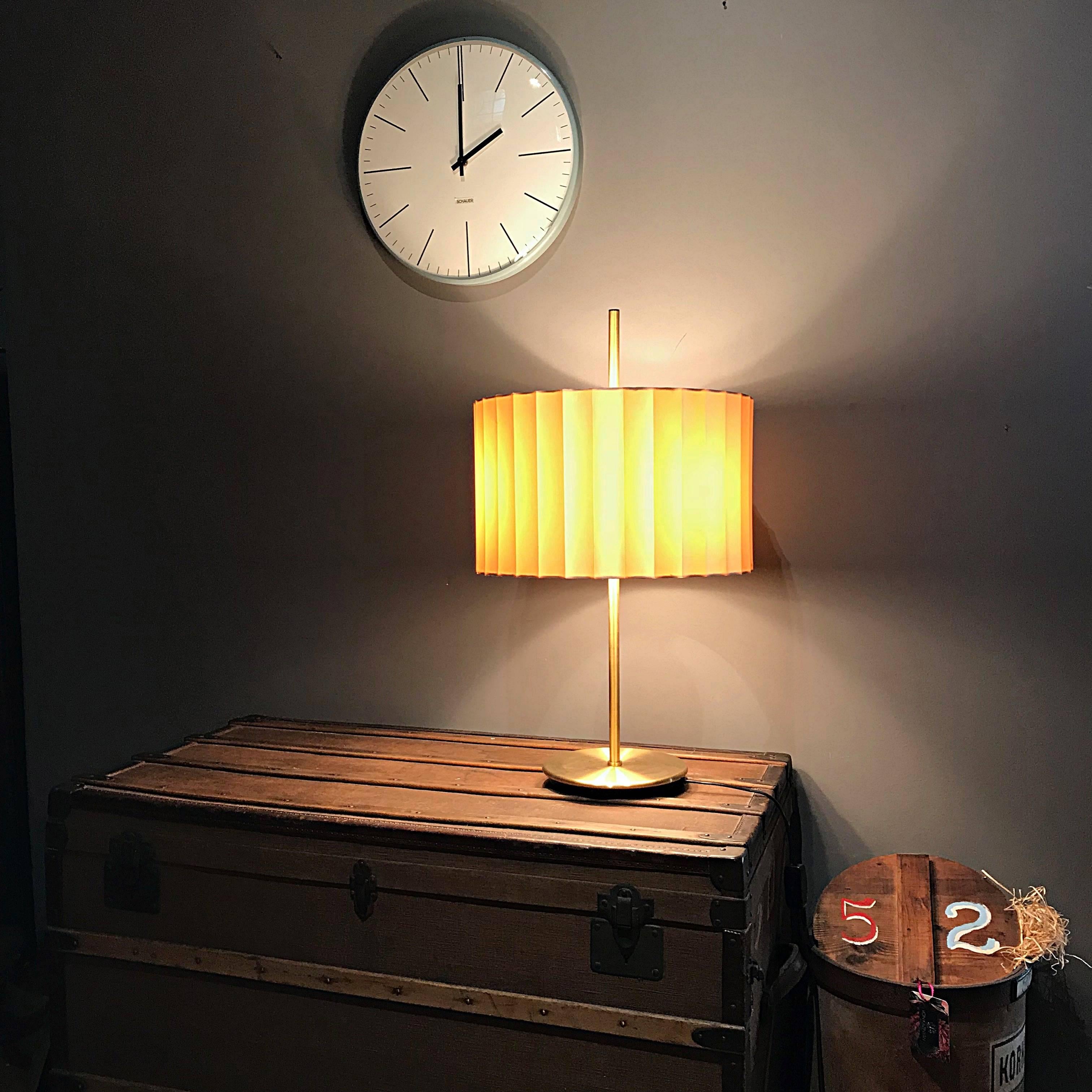 Simple and elegant midcentury table lamp manufactured by Staff Leuchten in Germany. The lamp is made of brass with heavy cast-iron base. The folded silk lampshade provides a smooth large-area light. The lamp is in excellent condition with nice