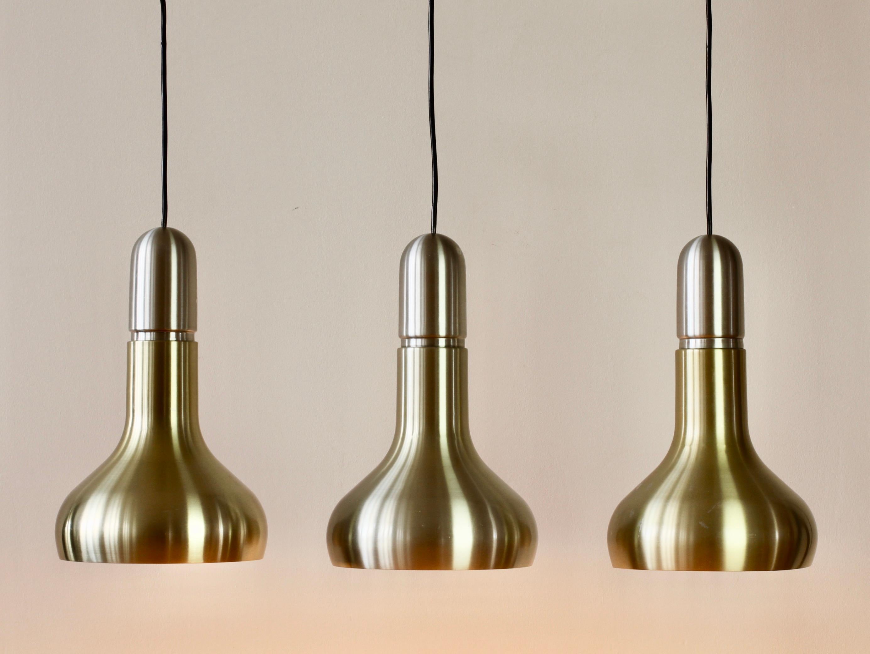 Mid-Century Modern hanging pendant ceiling lights / lamps by Staff Leuchten of Germany, circa 1970s. Anodised aluminium with 'brass' / 'gold' colored finish and white painted inner finish to reflect the light. Wonderful round circular hanging