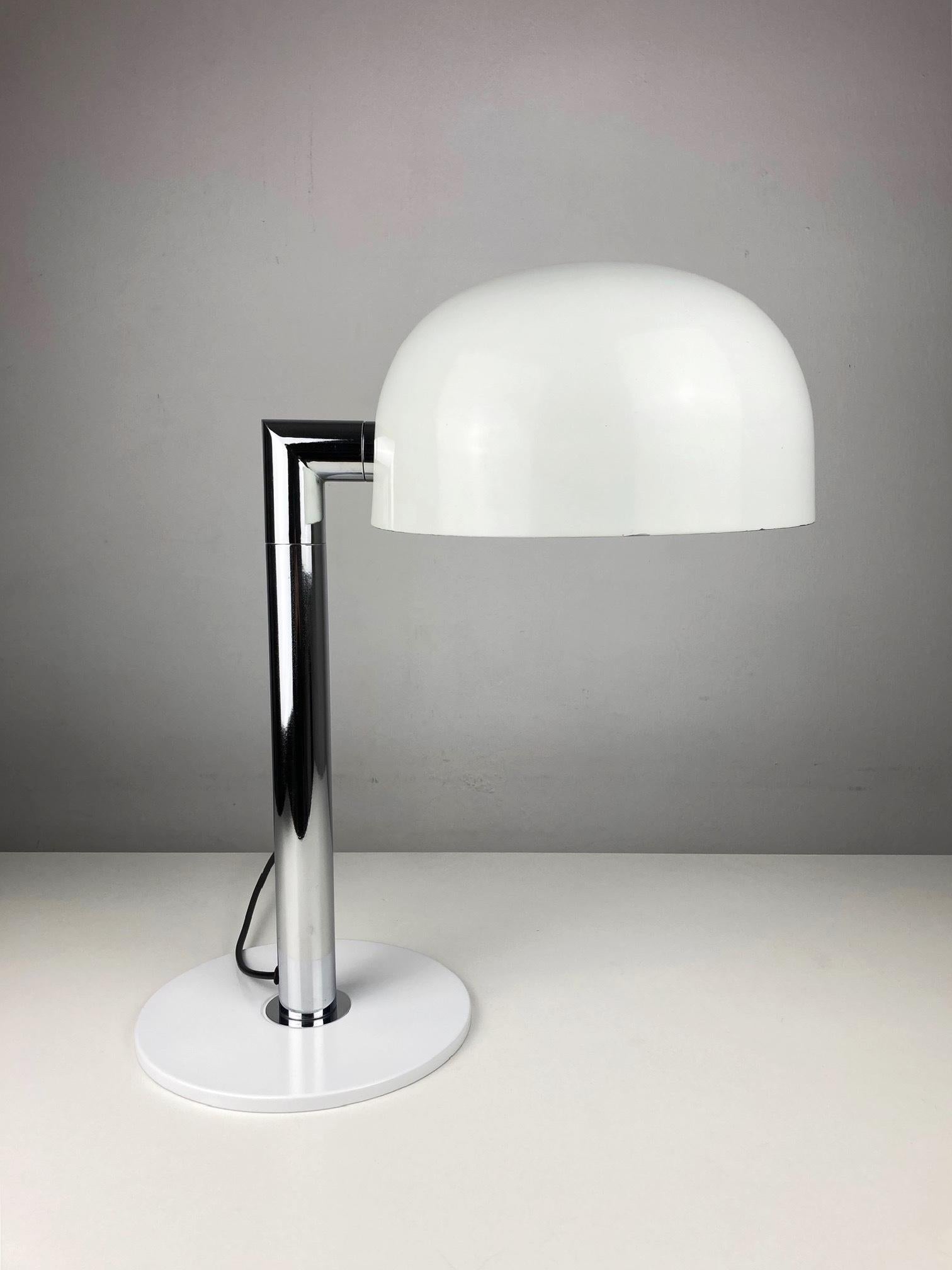Esta lámpara de sobremesa Staff de los años setenta encarna el diseño elegante y funcional típico de la estética moderna de mediados de siglo, combinado con una clara influencia de la Era Espacial. Fabricada con un cuerpo aerodinámico y minimalista,