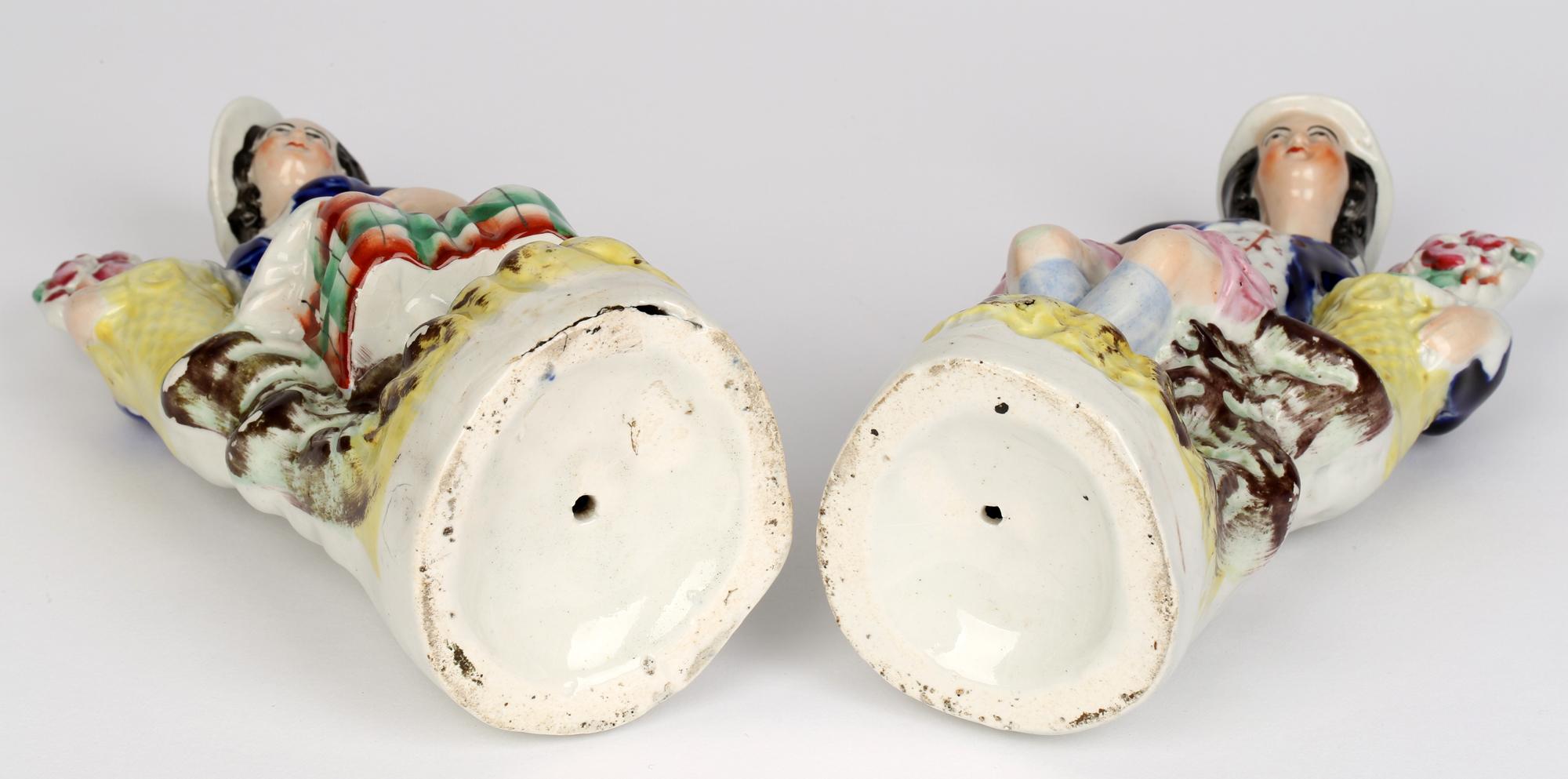 Une bonne paire de figurines en poterie du Staffordshire représentant un homme et une femme assis avec un panier contenant des fleurs, datant d'environ 1850. Les personnages sont assis sur un piédestal rocheux reposant sur une base arrondie moulée