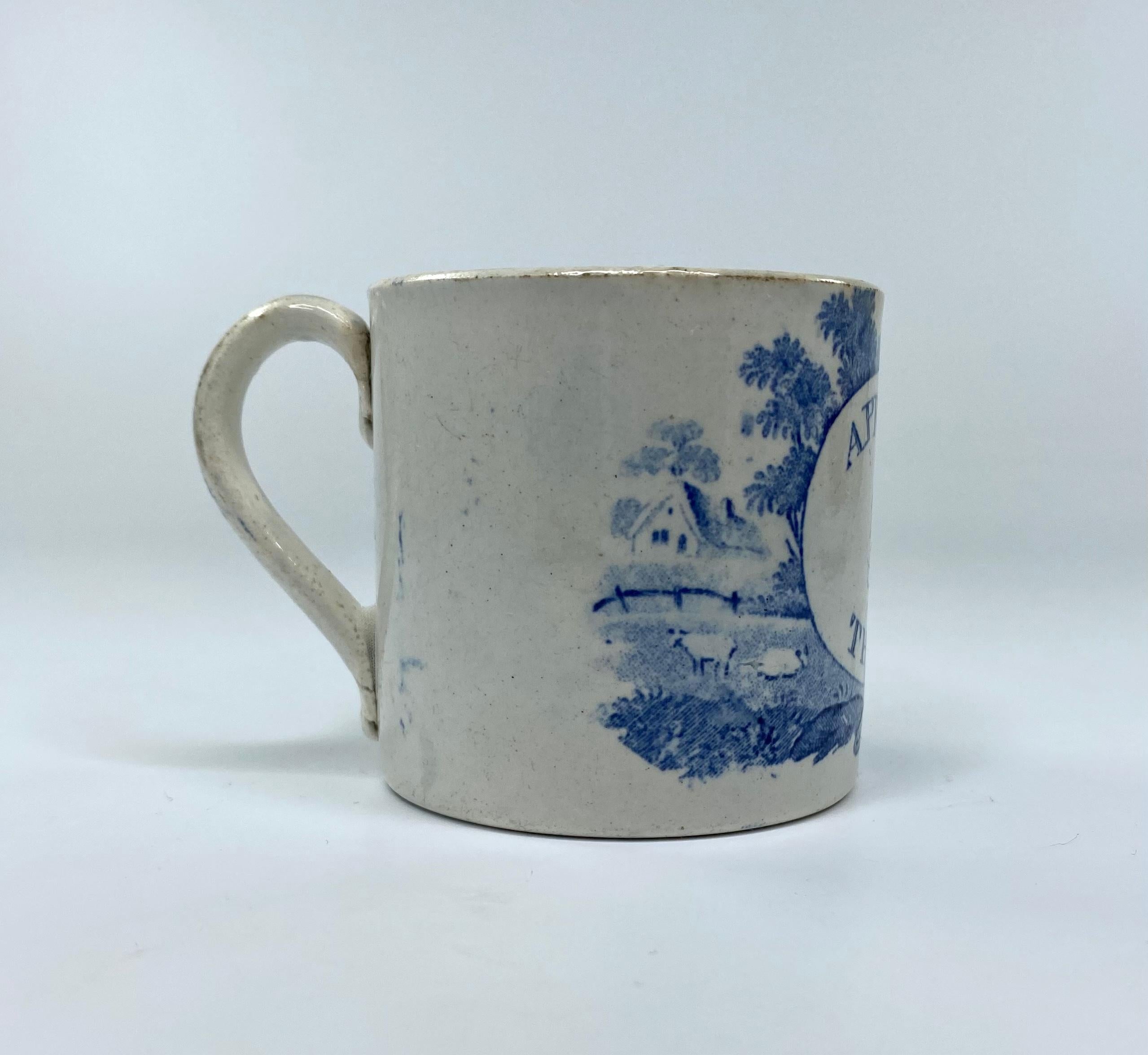 Staffordshire pottery child’s mug, c. 1830. Printed in underglaze blue, beneath a pearlware glaze, with a roundel inscribed ‘A PRESENT for THOMAS’. Set within a rural print, of sheep grazing beneath trees, before a farmhouse.
Having a simple strap