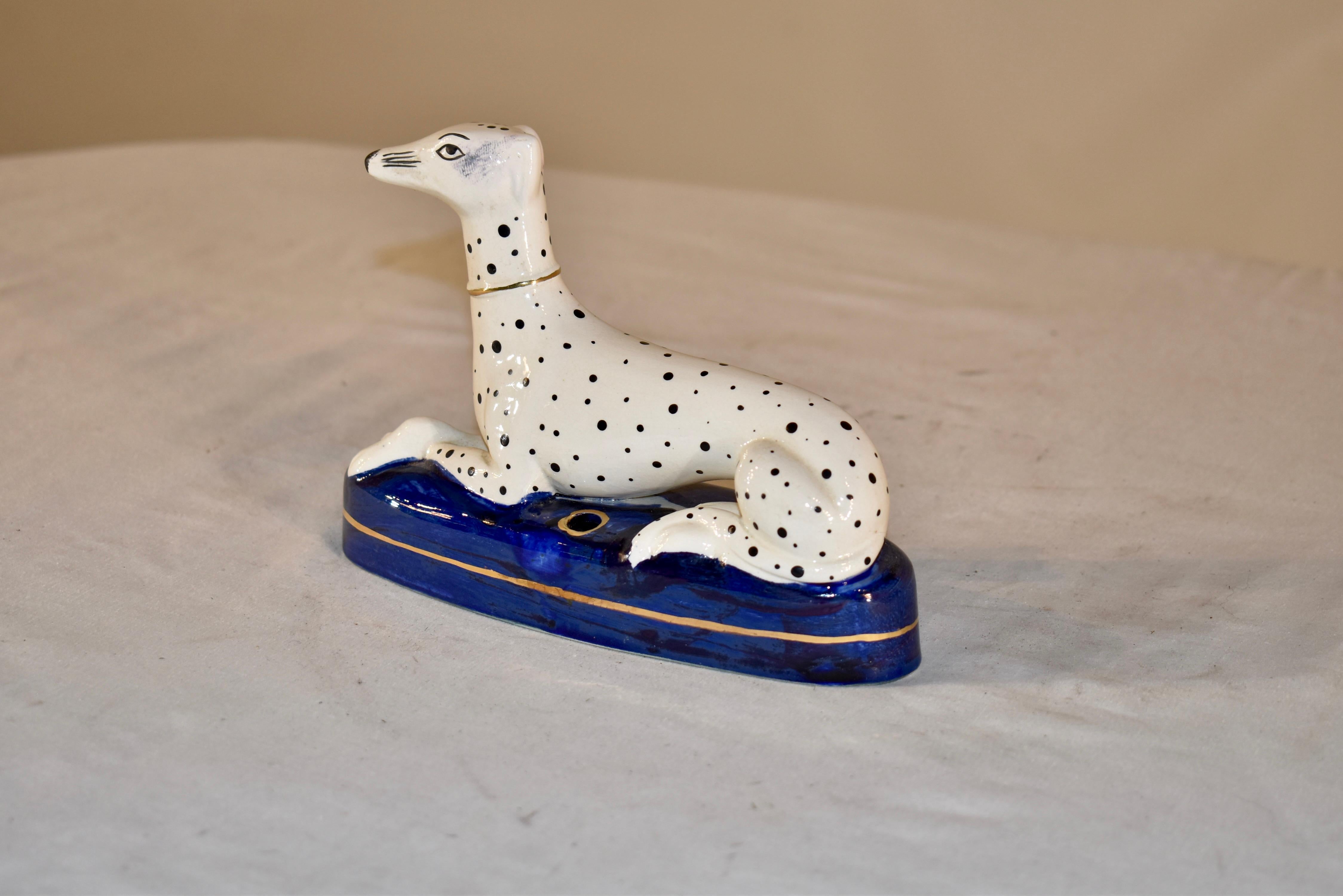 Vintage 1960's pen holder in the form of a Dalmatian made in the Staffordshire region of England.  The Dalmatian is recumbent, with front legs crossed in an elegant fashion, and sitting with its back legs together on the front side.  The quality of