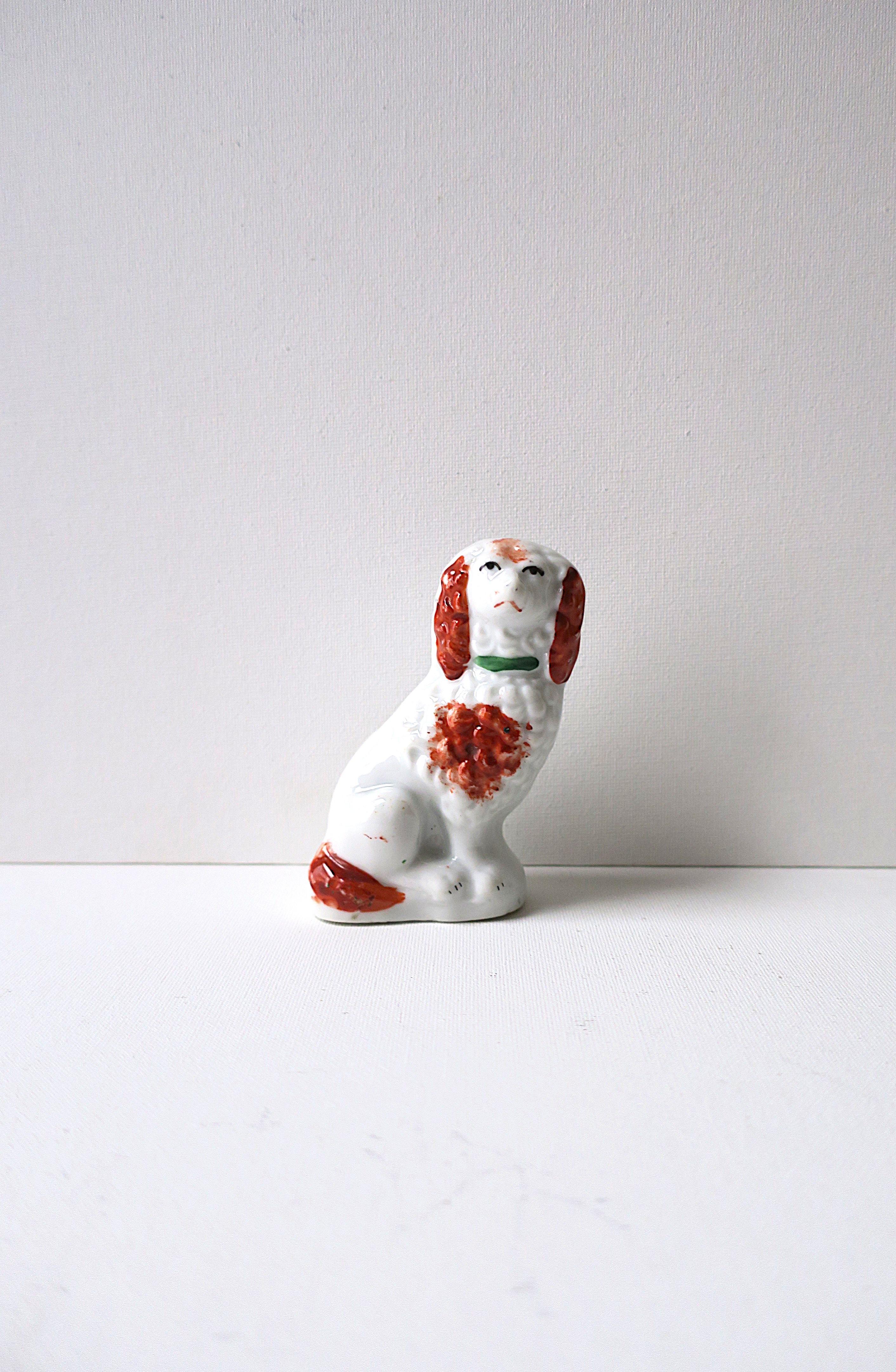 An English porcelain Staffordshire dog decorative object sculpture, Victorian design period, circa late-20th century, England. What a chic dog with loving eyes, green neck color, curls to hair, and black paw nails; all hand painted. A great piece