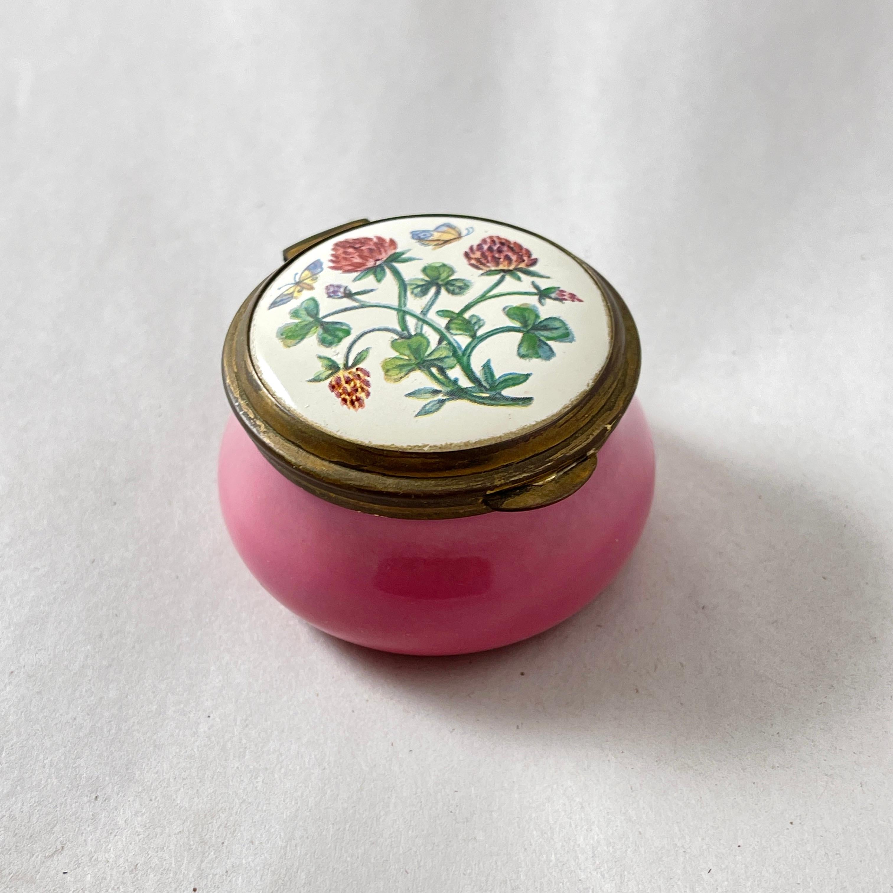 Caja de baratijas Staffordshire Enamels Old Hall, Inglaterra, hacia la década de 1980.

Un diseño de Trébol y Mariposa esmaltado a mano sobre una base rosa con marco de cobre.
También aparece una Mariposa en la tapa interior.

2 pulgadas de diámetro