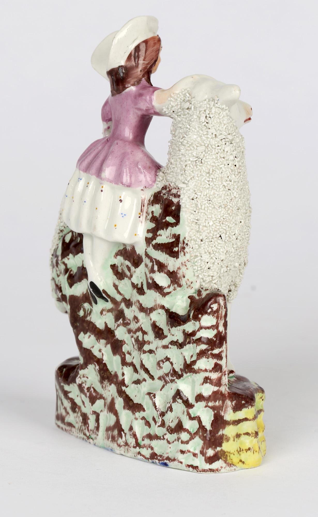 A fine and scarce antique English Staffordshire figure of a girl with a very large sheep dating from the mid 19th century. The figure stands on molded rockwork base with the girl standing behind the sheep with one hand resting on the head and the