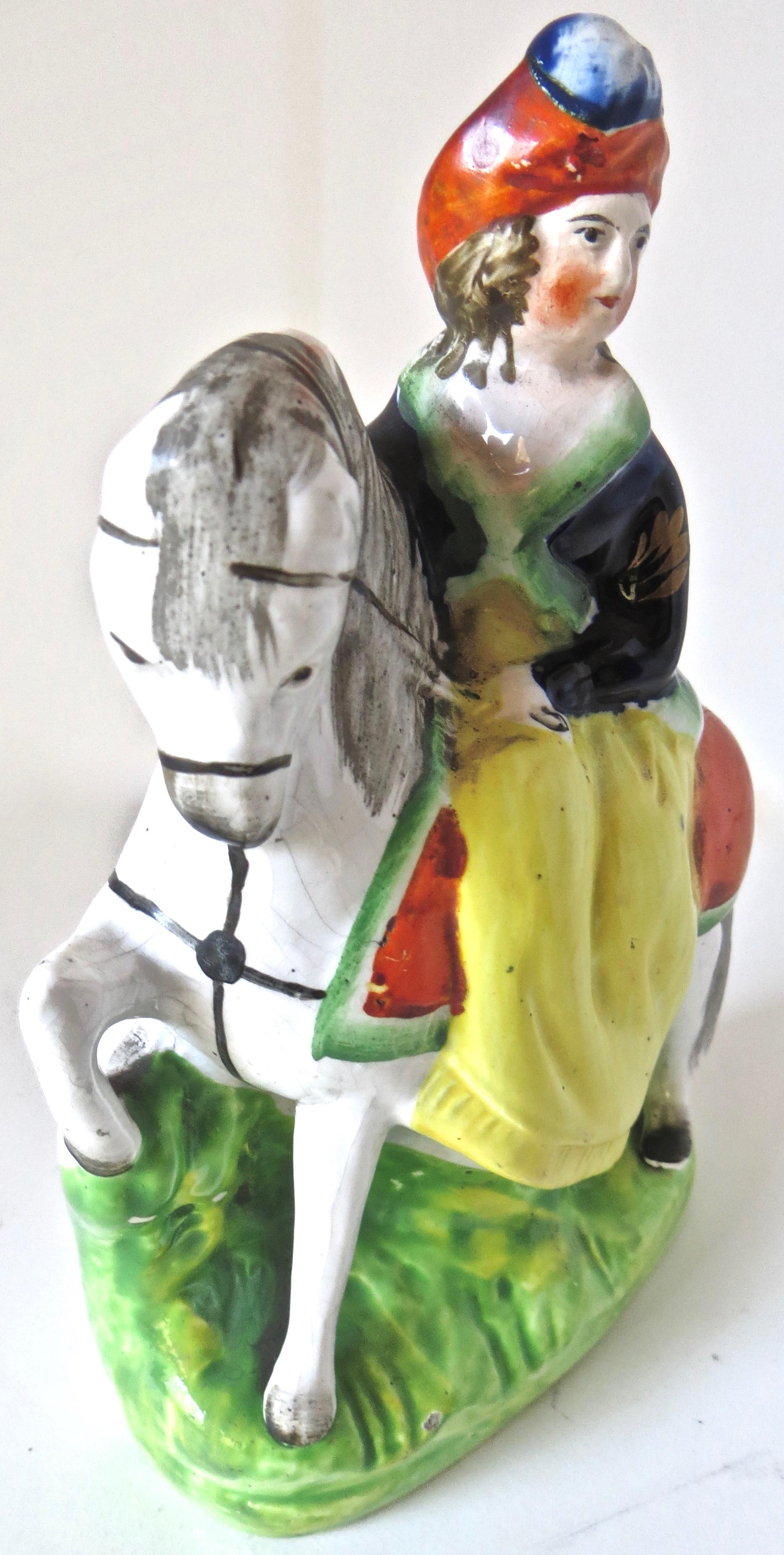 Late 19th century Staffordshire porcelain figurine depicts a young well-dressed lady riding a handsome white horse 