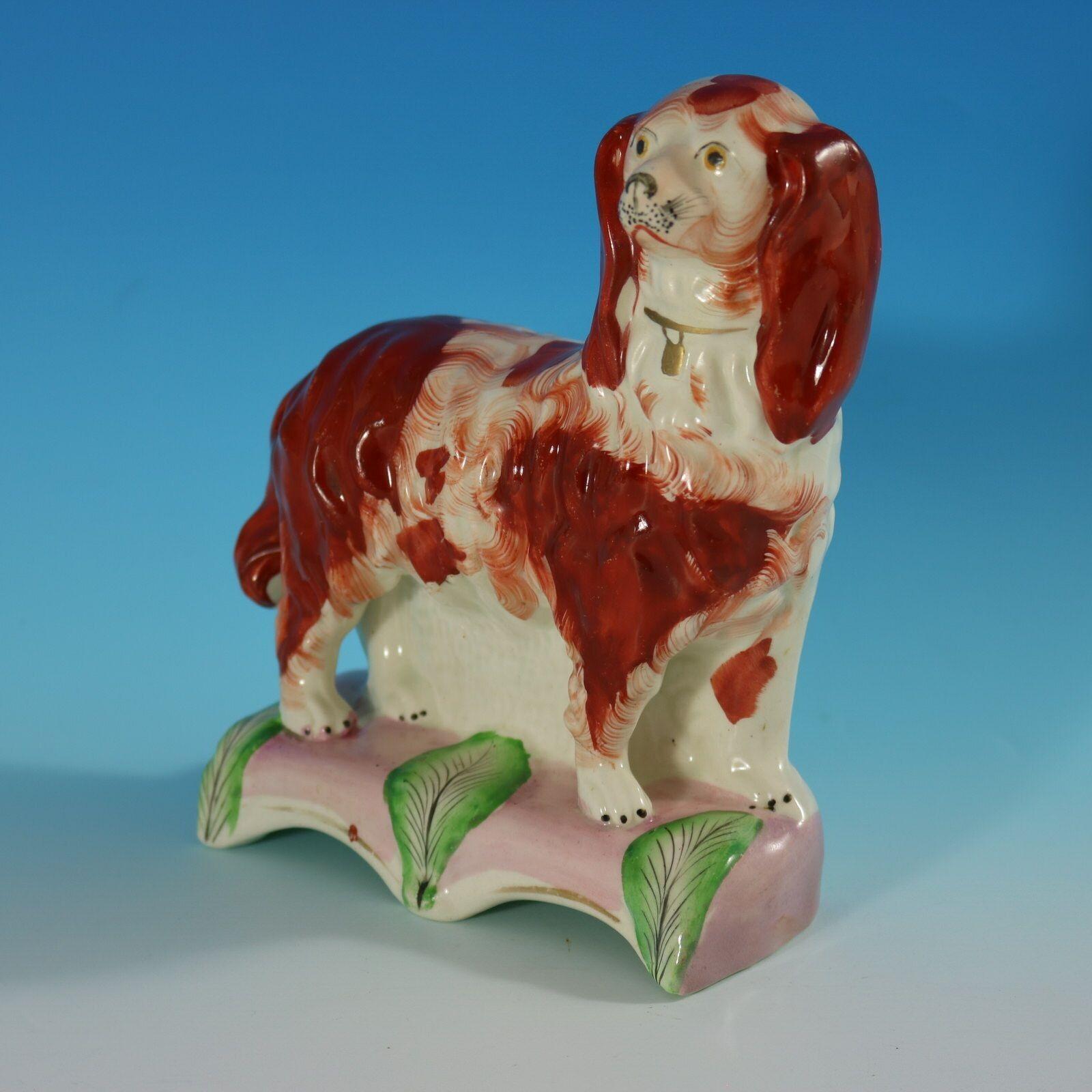 Staffordshire Pottery figure which features a King Charles spaniel, stood on a leaf embellished base. Dull gilt embellishment.