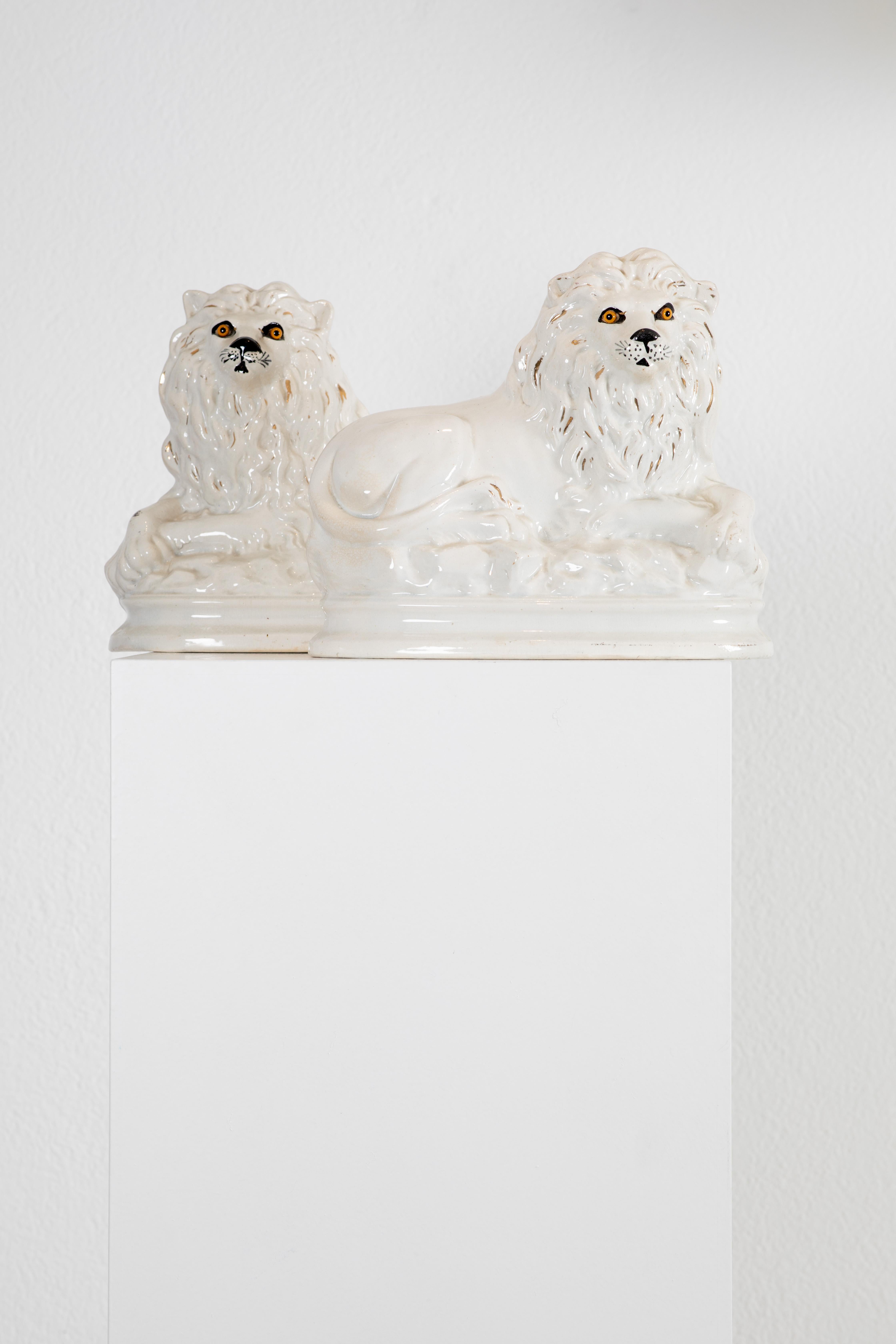 Questa splendida coppia di leoni decorativi dello Staffordshire, realizzati in epoca vittoriana, incarna un'eleganza senza tempo e un'eccezionale maestria. Realizzati in ceramica con occhi in vetro, questi leoni sono simboli di forza e grazia. I
